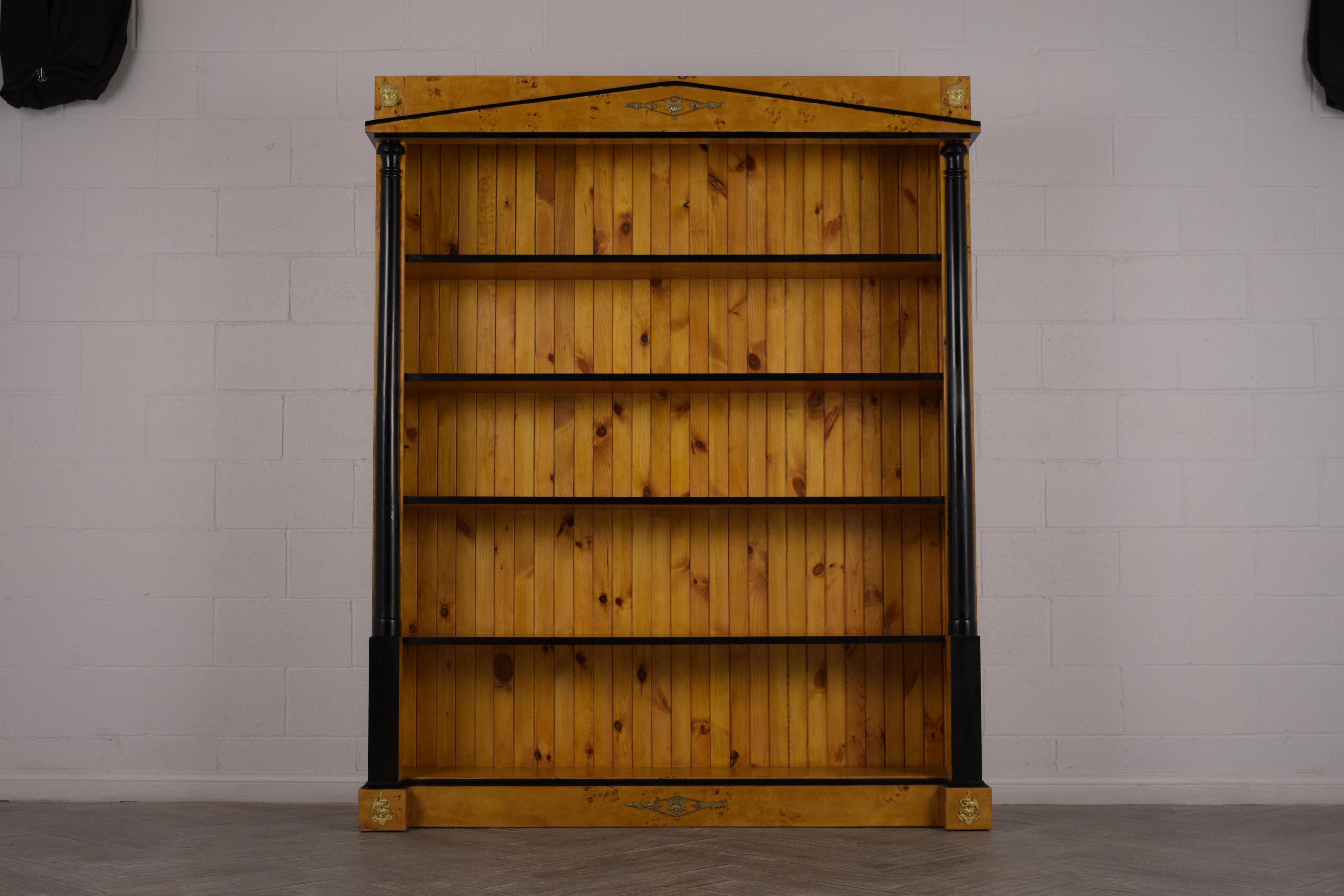 This Biedermeier-style Open Bookcase is made from solid wood covered in exotic burled veneers and is stained in rich golden color with black accents. These shelves feature brass accents along the top and bottom borders, and the interior features