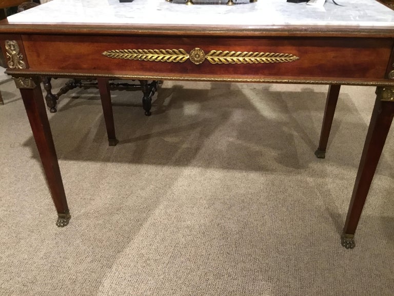 Empire table with Egyptian style bronze mounts at all
Corners including the sides having white marble with
Gray veining throughout.
Mahogany apron and legs decorated with bronze doré
Mounts. One side drops down and has a lock and key.