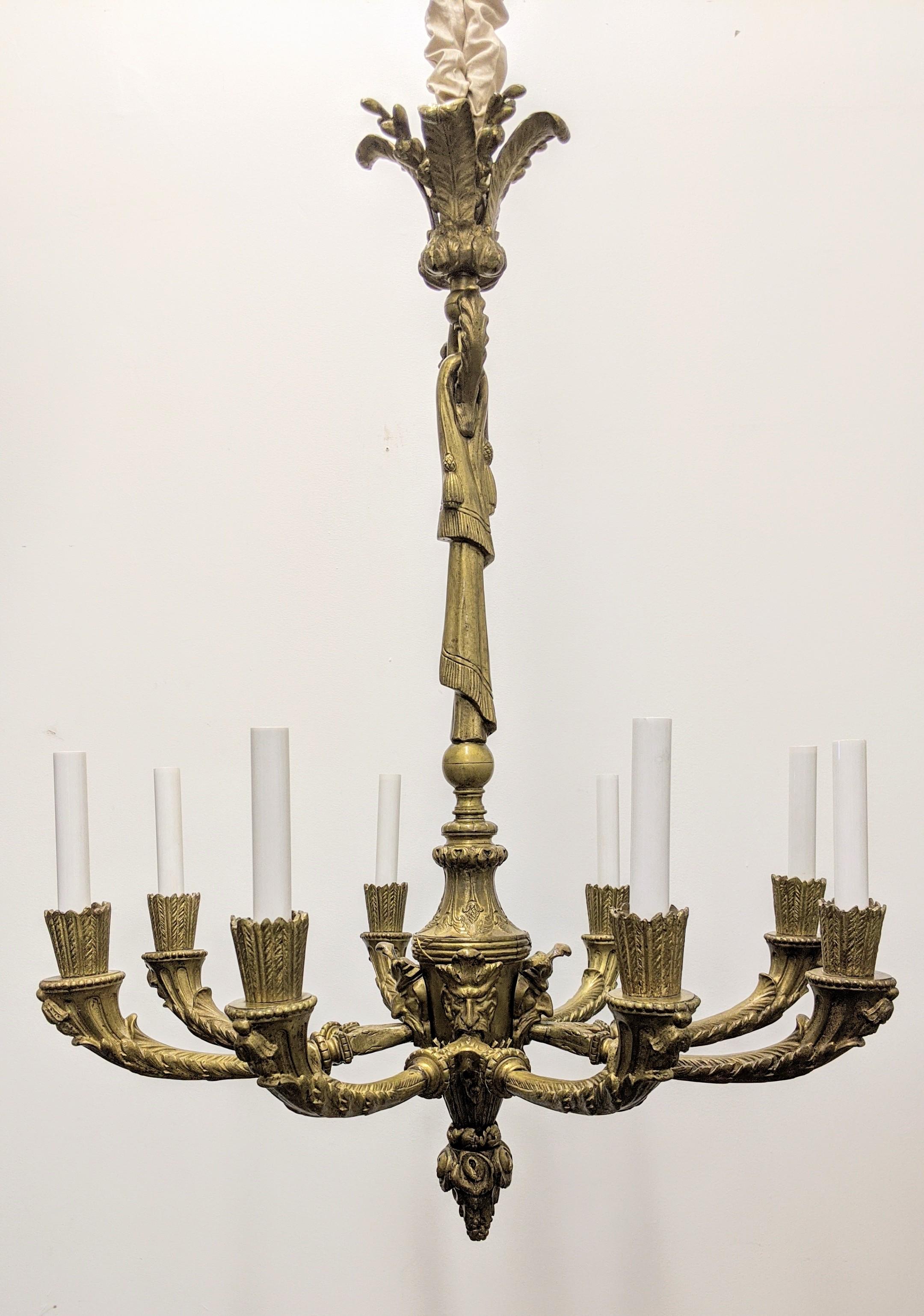 Antique empire chandelier, circa 1870's - 1880's. Originally made for candles, converted to electric. Exquisite bronze casting details with four double arms eight lights with decorative motifs throughout. Rewired to U.S. standards, accommodate