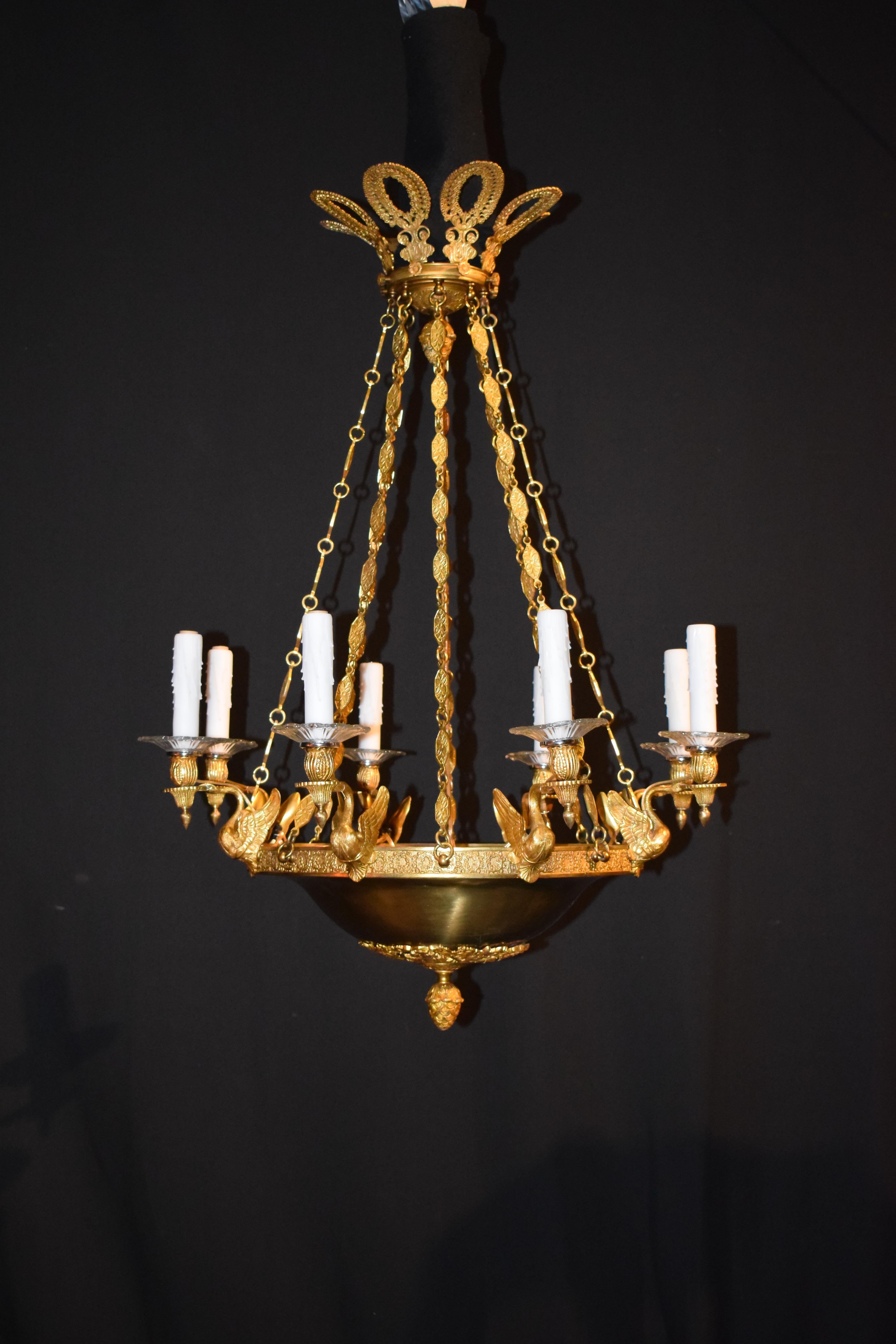 A Very Fine Gilt Bronze Chandelier in the Empire taste, featuring gilt bronze swans issuing lights. An exquisite eight wreath top canopy. 8 lights. 
France, circa 1900.
Dimensions: Height 39
