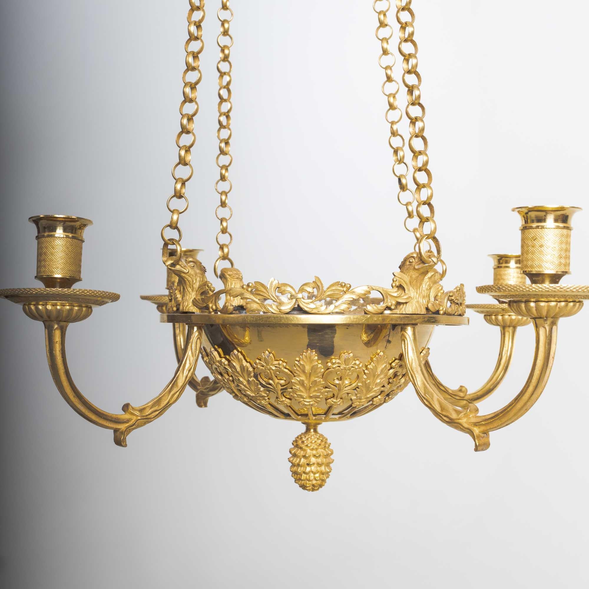 Four-armed chandelier made of fire-gilded bronze with eagle heads and acanthus leaf decor.