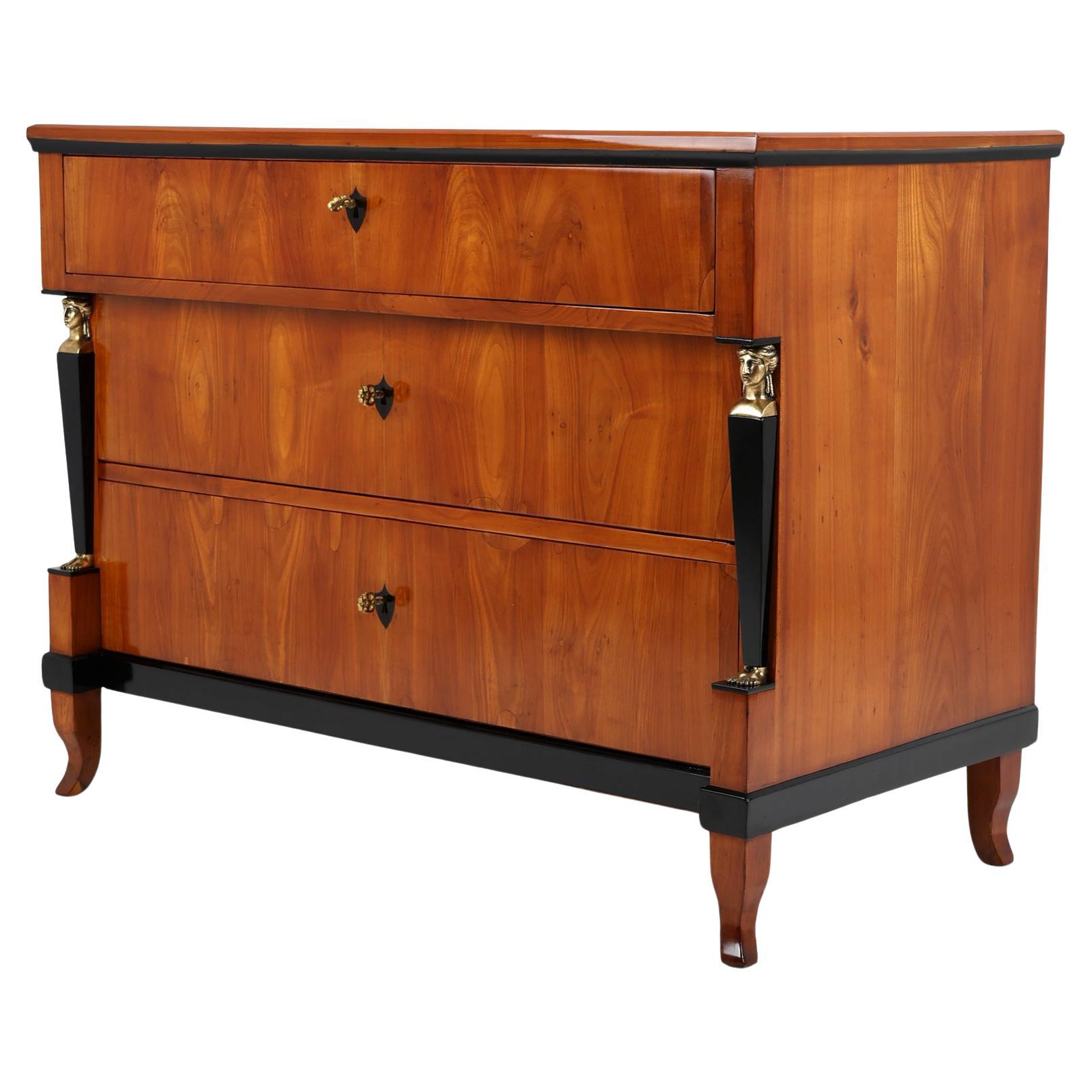 Empire Chest of Drawers with Caryatids
South Germany, 1815
Cherrywood

Very elegant German Empire Chest, ca. 1815.
This Chest of drawers rests on four splayed feet and exhibits lovely use of veneers. Wonderful, bright cherry veneer runs over the
