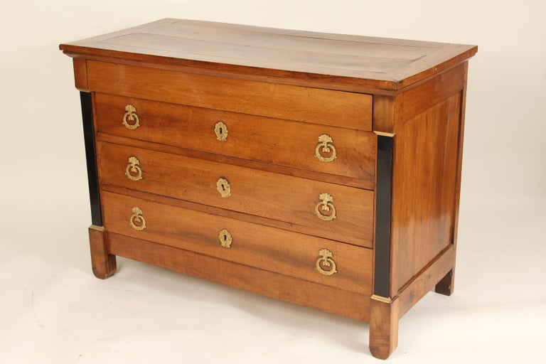 Empire fruit wood chest of drawers with gilt bronze hardware and ebonized columns, 19th century. No keys.