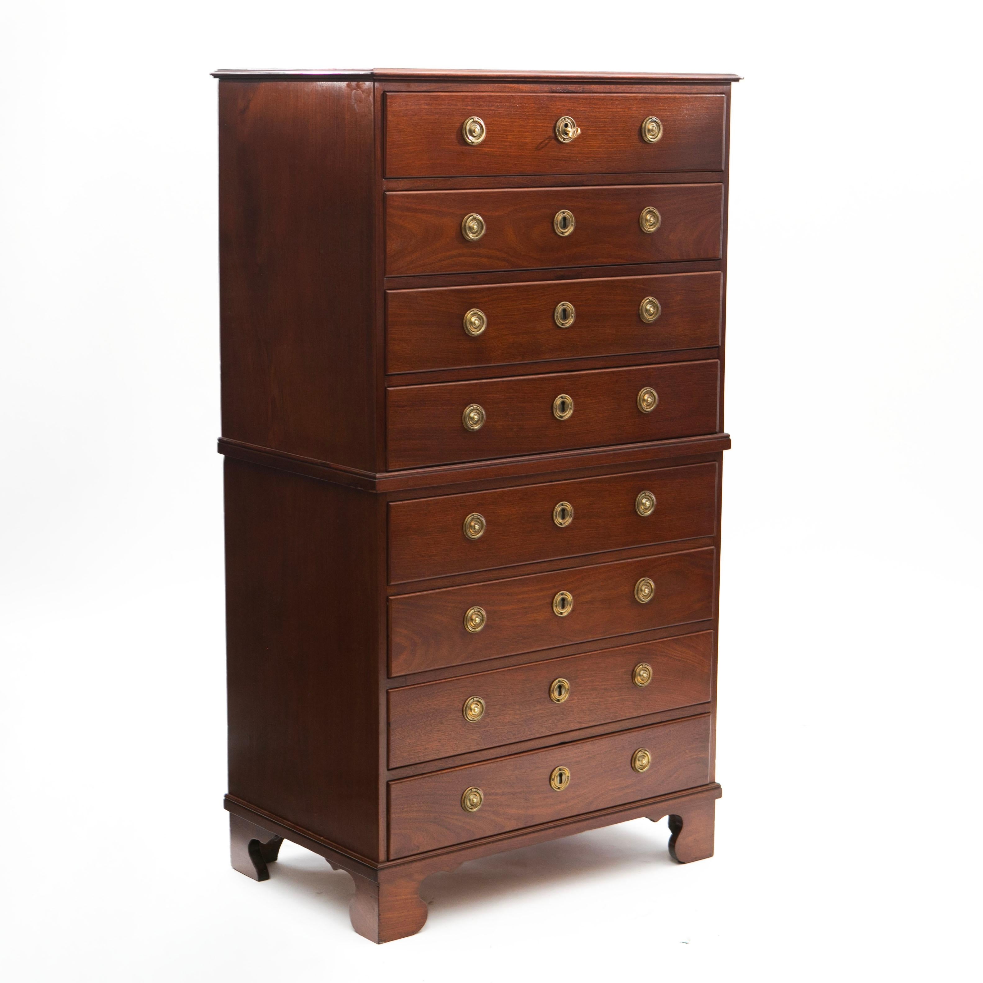 A tall Empire chest of drawers, also known as a 'Chest on Chest,' composed of two pieces. This model is expertly crafted from solid, high-quality Cuba mahogany with original brass fittings. It features a simple yet elegant design with 8 drawers, all