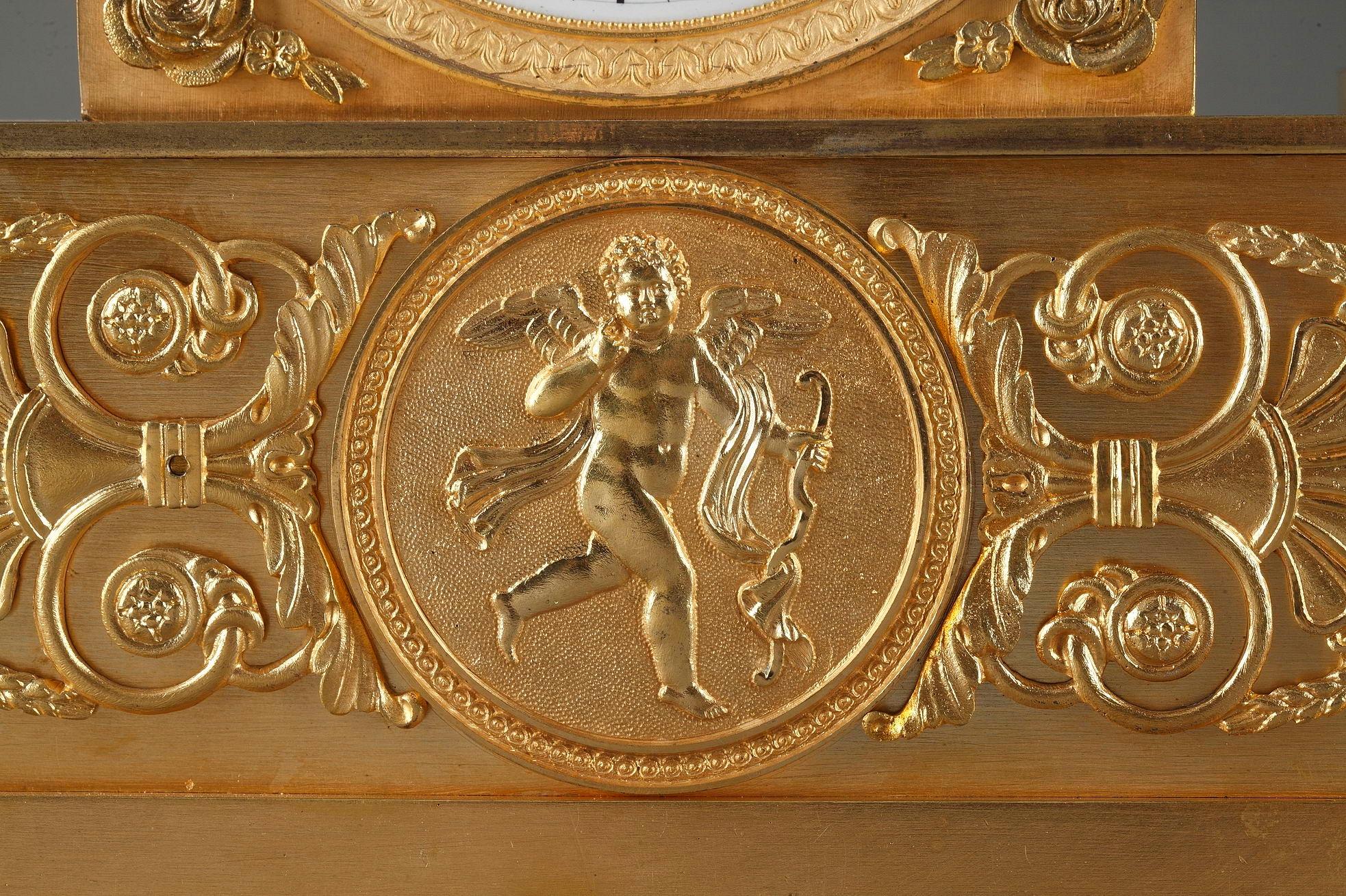 Pendule Empire français finement ouvragée en bronze doré, représentant une jeune fileuse portant une robe classique, assise sur le cadran près d'une lyre et d'une aiguière. La base est accentuée par de généreux rinceaux, une palmette et un médaillon