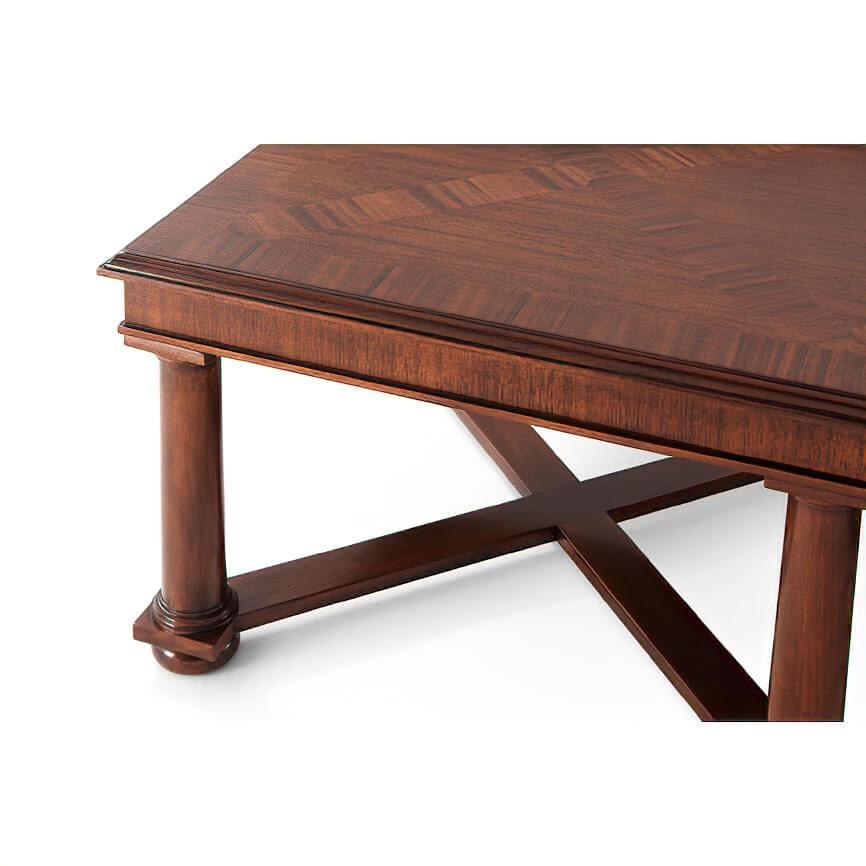 Empire style cocktail table. The molded-edge rectangular top is beautifully crafted in ribbon mahogany veneer parquetry and stands on bold column legs joined by a network of X-stretchers. Set on turned disc feet.

Shown in Kings finish
Available