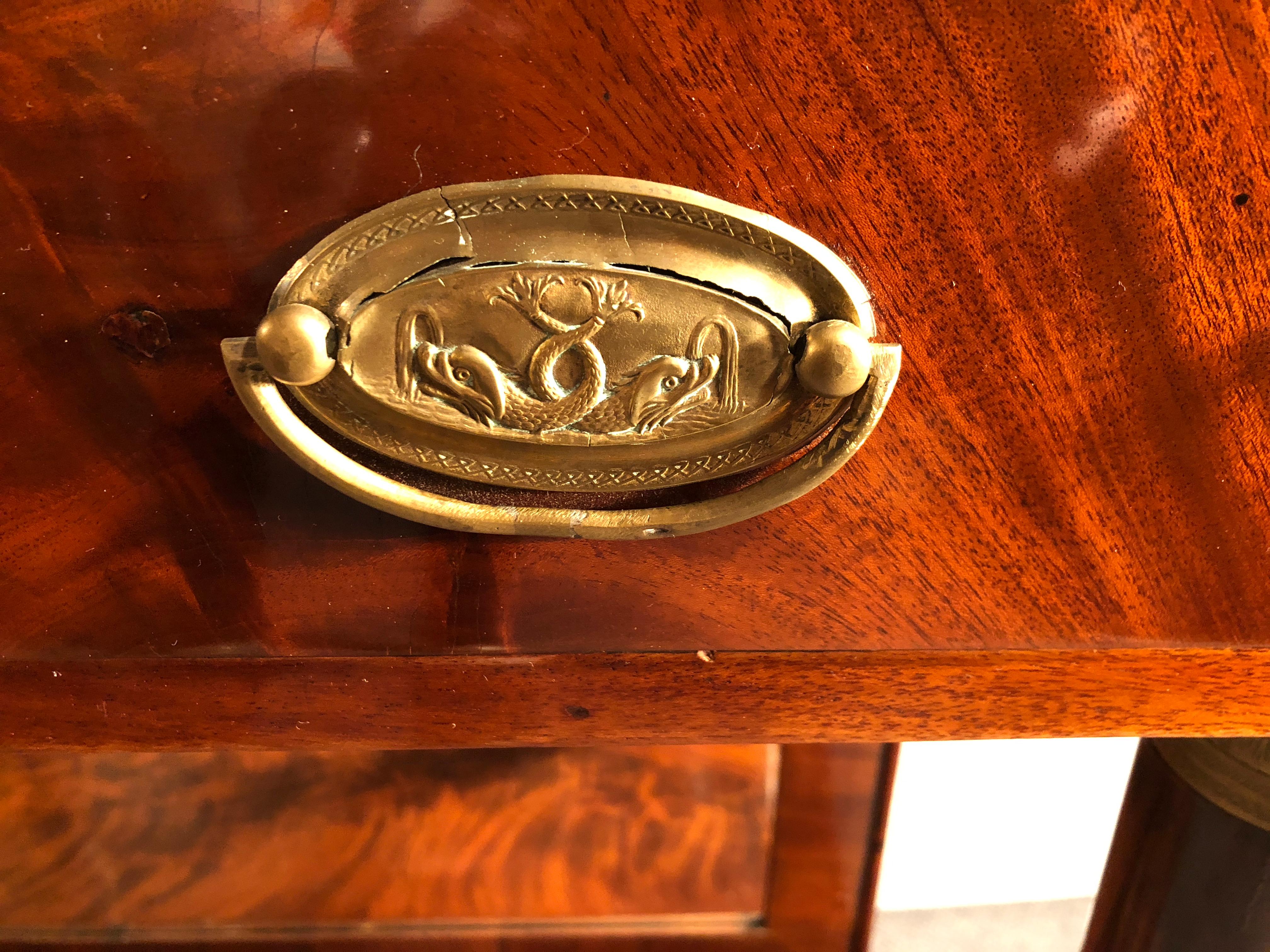 Console Empire d'origine, France, 1820, en placage d'acajou avec garnitures en laiton d'origine. Les élégantes colonnes avec leurs chapiteaux et leurs bases en laiton reposent sur une base rectangulaire. Le dos est décoré d'un miroir. La table