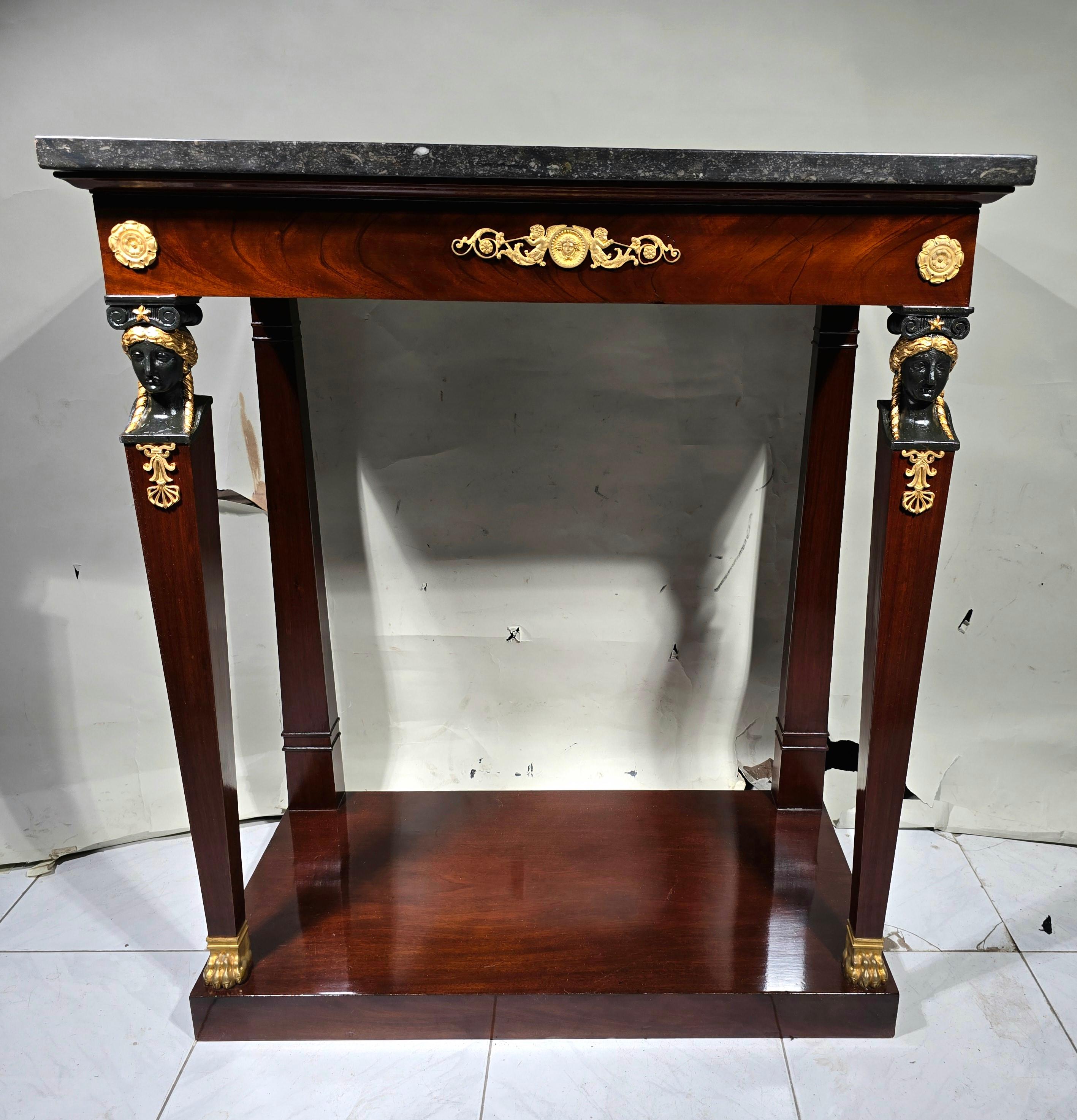 This mahogany console epitomizes the elegance and refinement of the Empire era. Its front legs adorned with caryatids and its rear legs in pilasters add a touch of grandeur to its timeless design. Dating back to the Consulate period, this piece is a