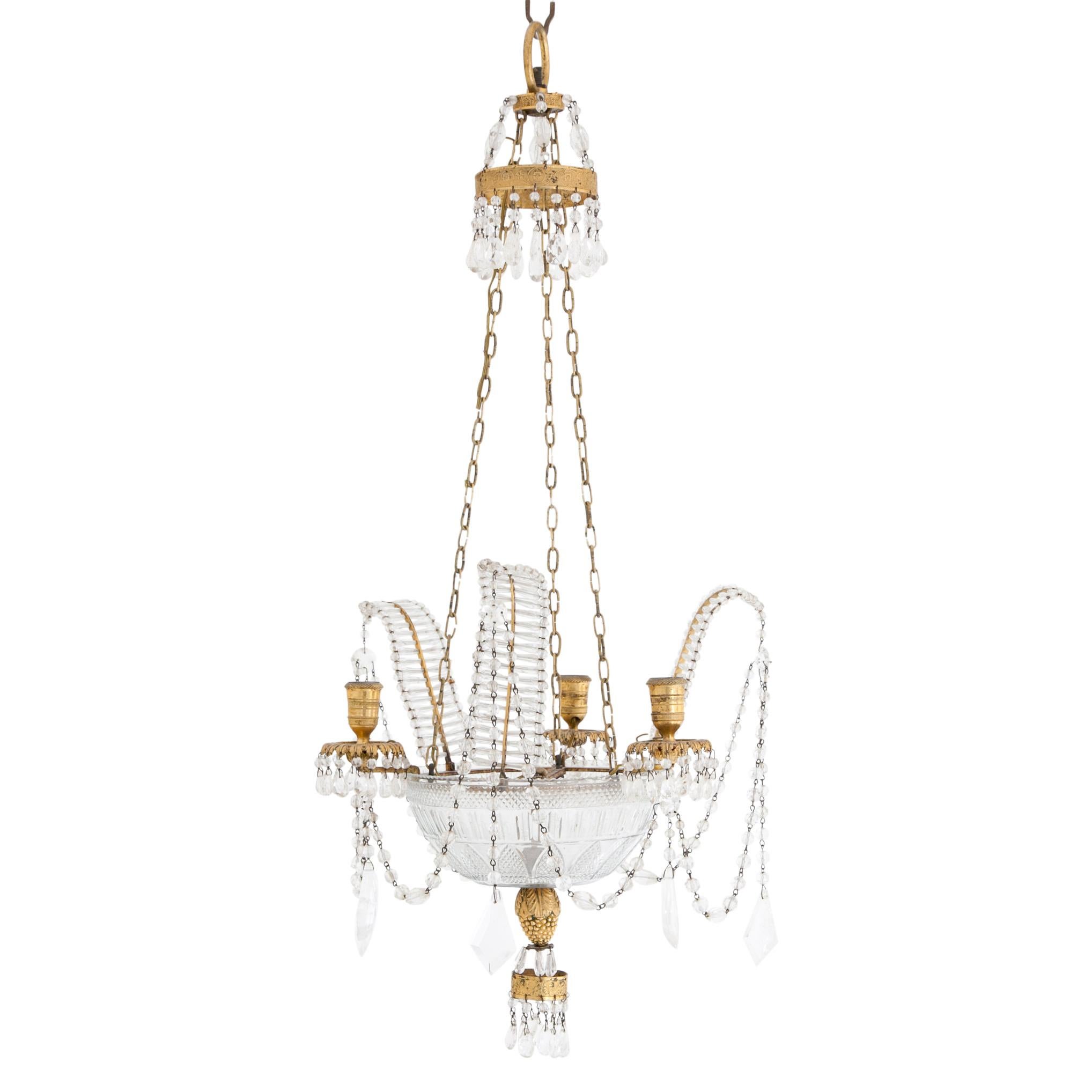 Four-light chandelier with a facetted glass dish, clear quartz prisms and fire-gilt mounting, probably Vienna, circa 1800. Measurement: 86 x Ø 40 cm.