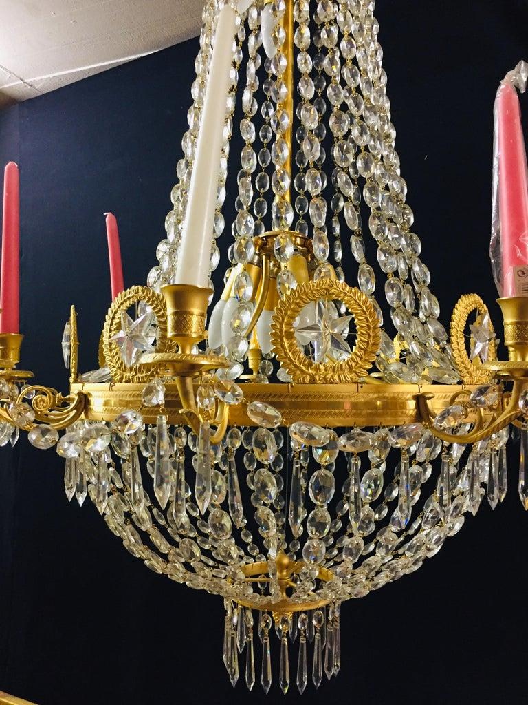 Empire crystal chandelier, Charles X, high-gloss gilding exceptionally fine, engraved and cast bronze Mattvergoldet. Basket-formed corpus from handcut prisms (over 1050 pieces). Connected through wide ornamental reliefed. There from, nine-light arms