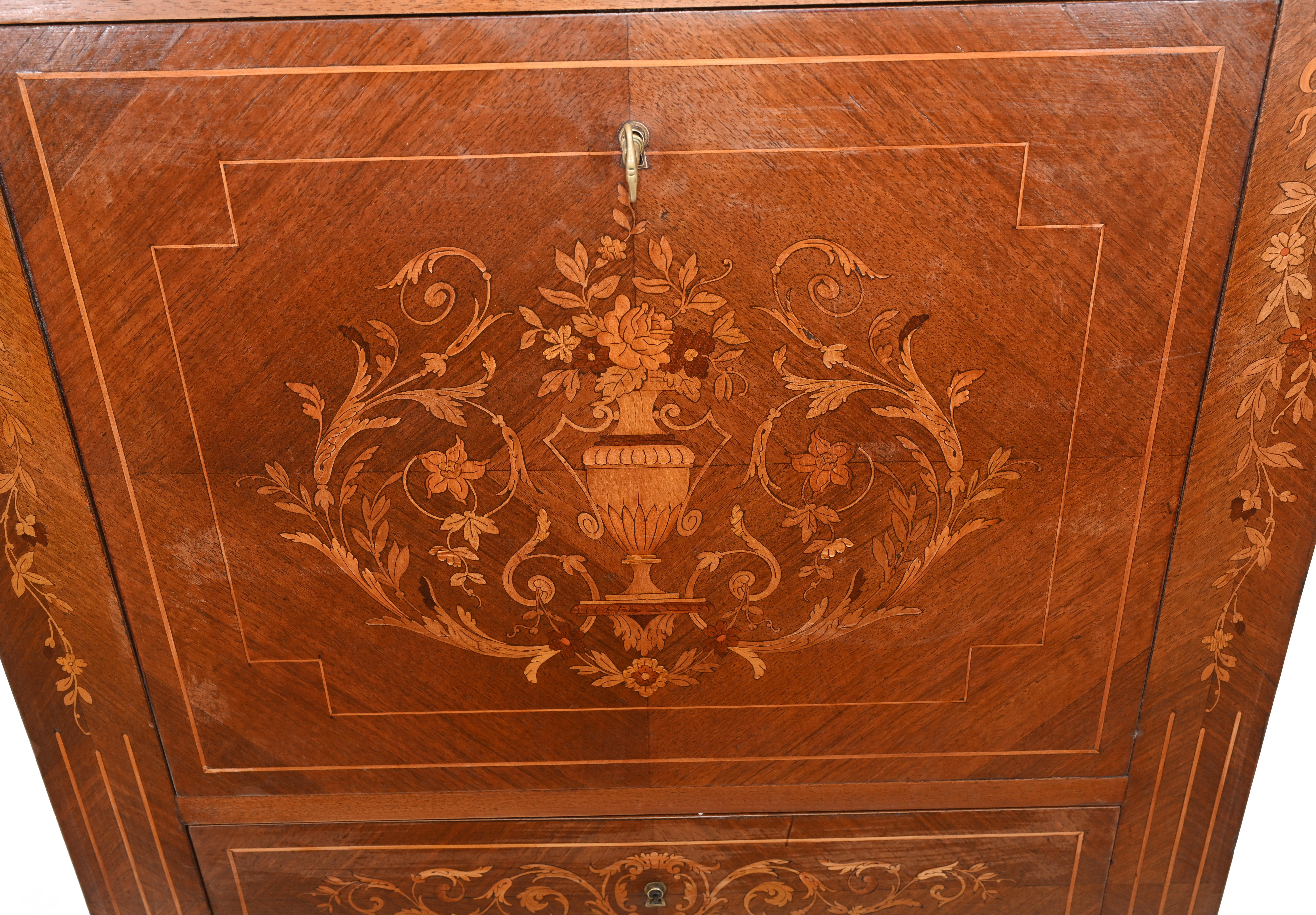Stylish French Empire escritoire desk we date to circa 1880
Elegant inlay on the all sides shows floral motifs
Front opens out to reveal writing surface covered in red leather
Various cubby holes and drawers 
Charming space saving piece
Bought