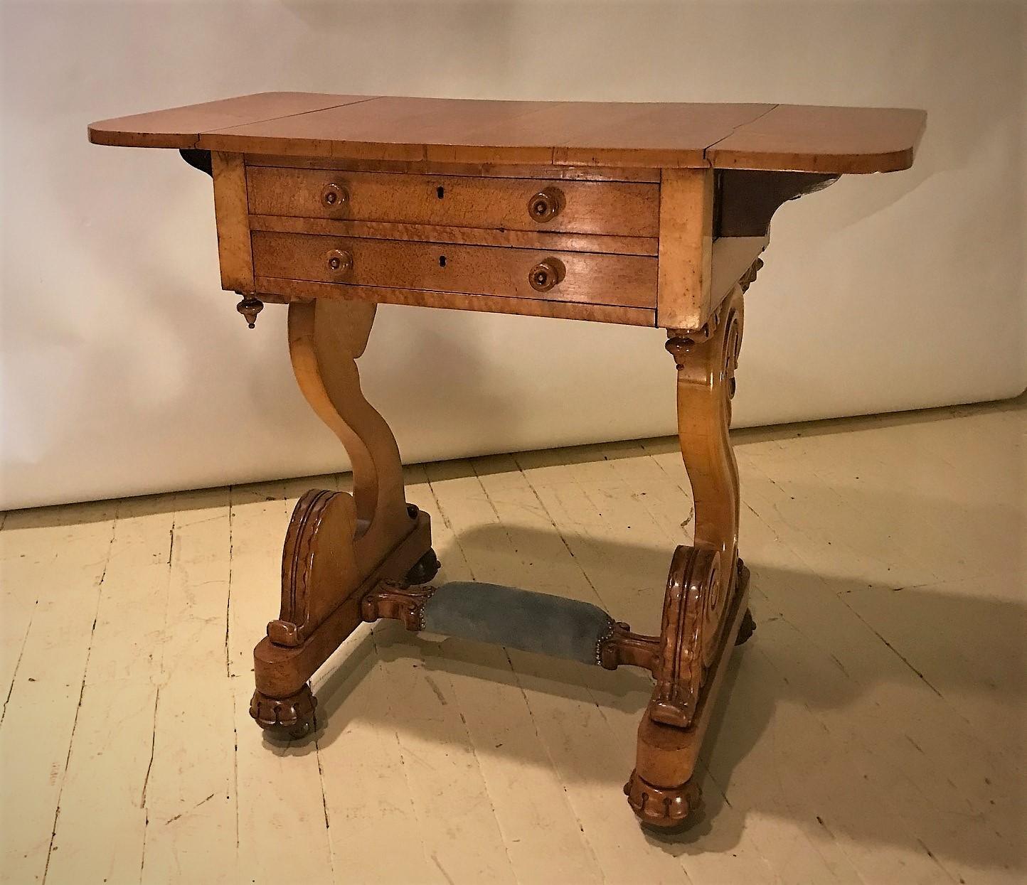 This beautiful Empire drop-leaf 2-drawer stand is a real show-stopper! Made in Brussels, Belgium in the early 19th Century of highly-figured birdseye maple. Originally it had a sewing basket that has been replaced with a slide-out leather writing