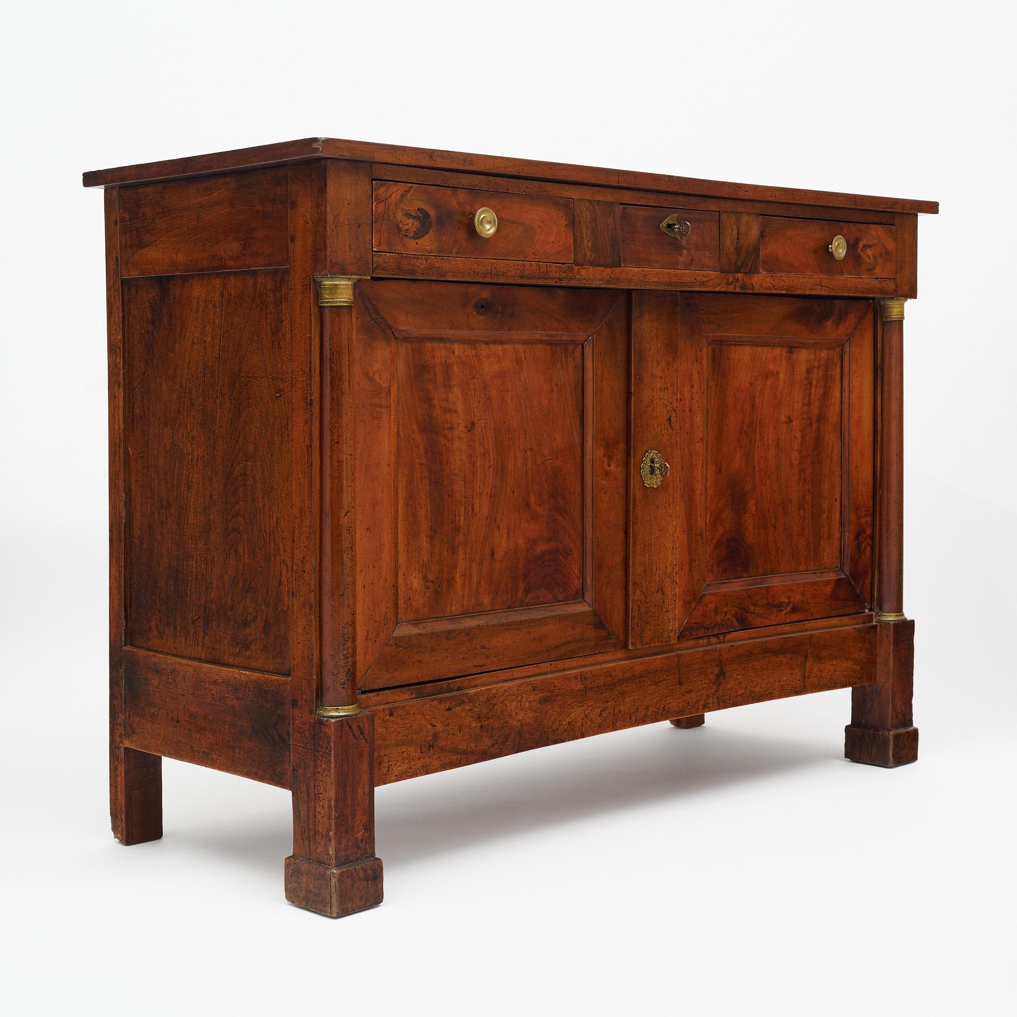 Buffet proveniente dalla Francia del periodo dell'impero. Questo pezzo è realizzato in legno massiccio, principalmente in noce. Ci sono due semicolonne con dettagli in bronzo in alto e in basso. Nella parte superiore sono presenti tre cassetti a