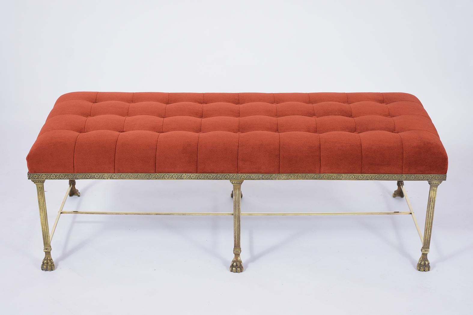 This antique brass bench has been professionally reupholstered in bright red color mohair fabric and given a square tufted design. The bench has new foam inserts, top-stitch details, a comfortable seat, and a sturdy brass frame. This French Tufted