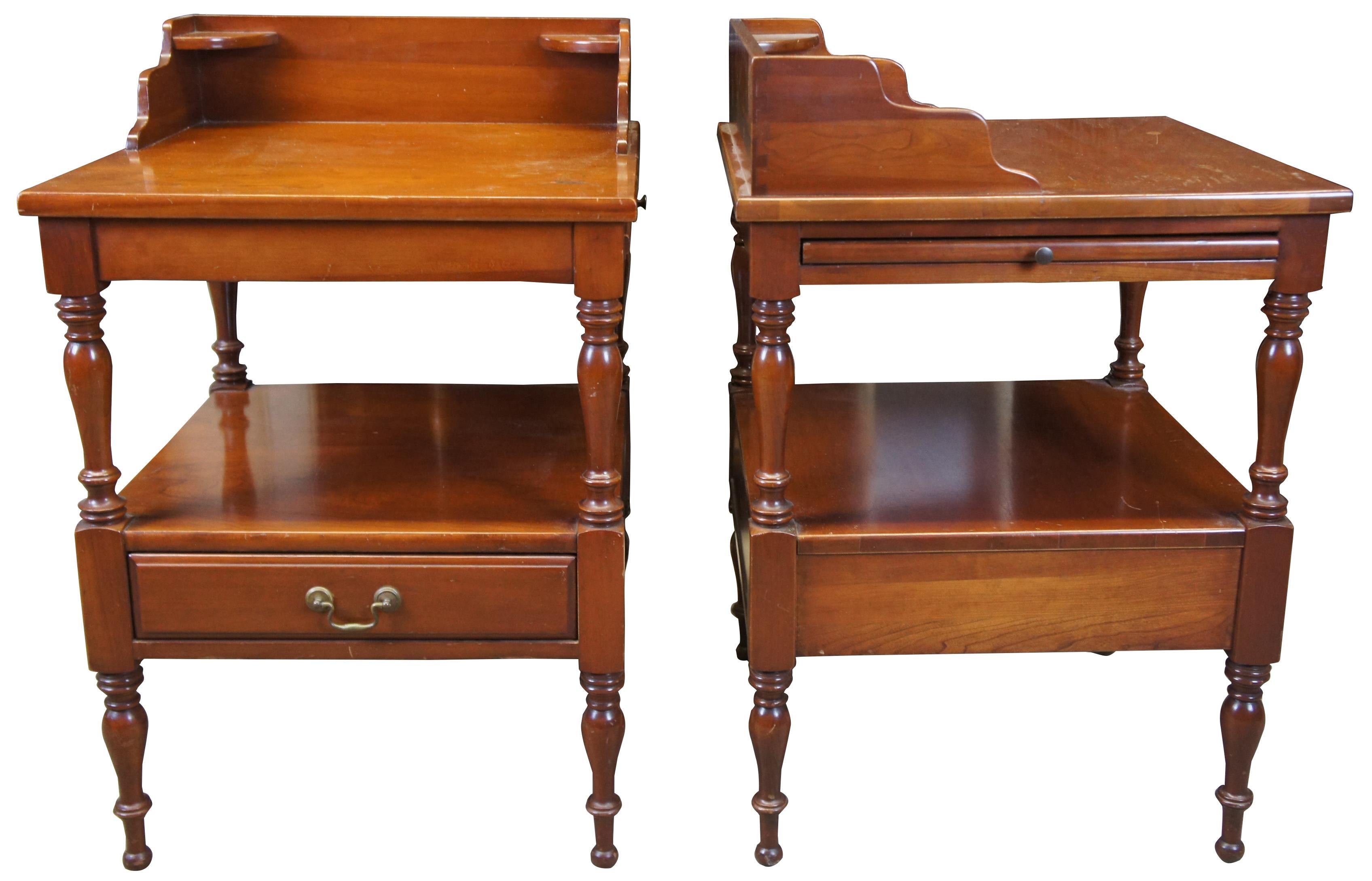 Two Empire Furniture Corp colonial / early American style side tables. Made from cherry with a two tier design with pullout shelves, lower drawer and backsplash, circa 1957. Empire Furniture Company is no longer in business. The company’s vintage