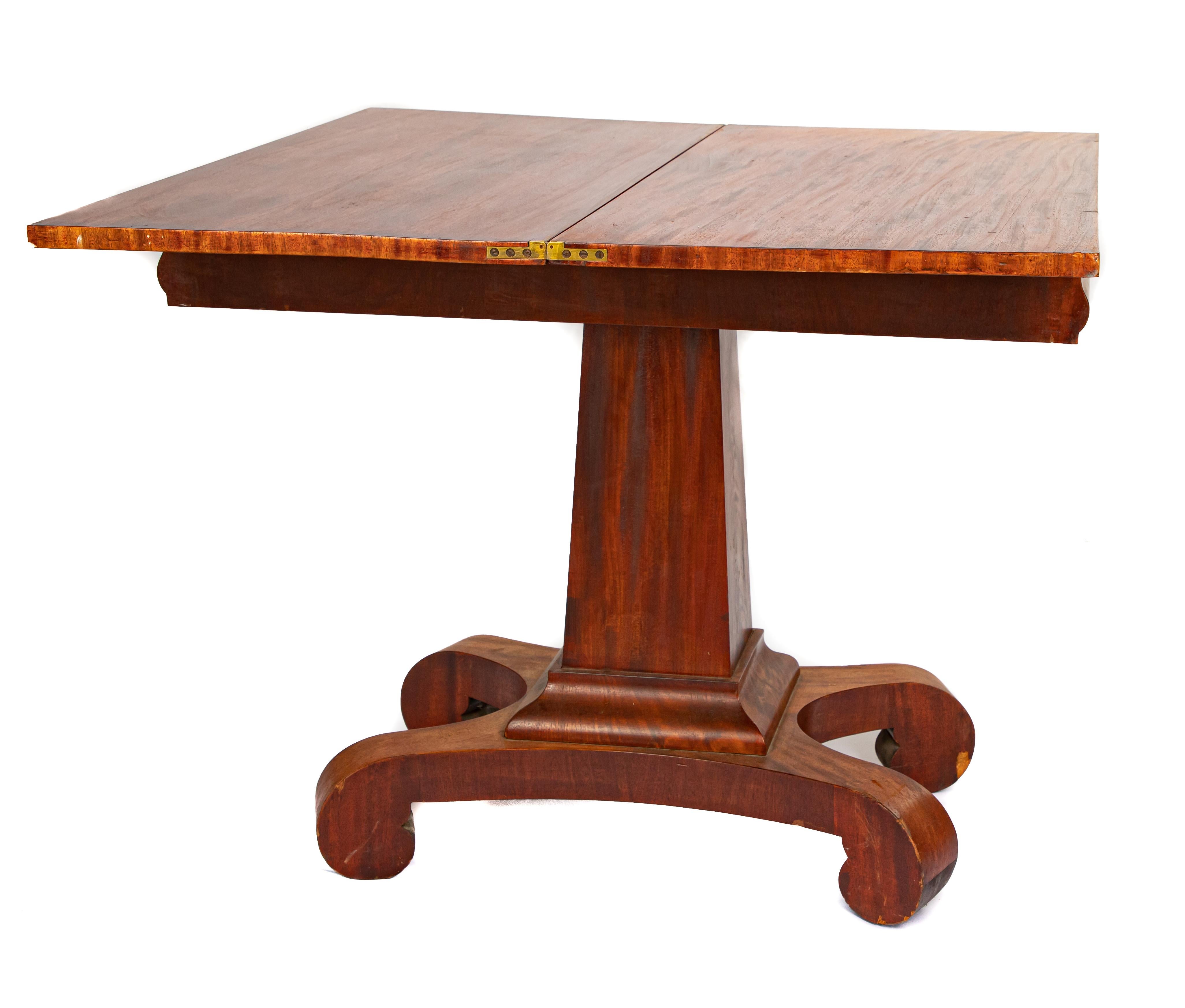 Offering this stunning burled empire game table. Starting on a large pedestal base it rises on a square up to a stately rectangle top. The top twist and opens to a square top game table.
