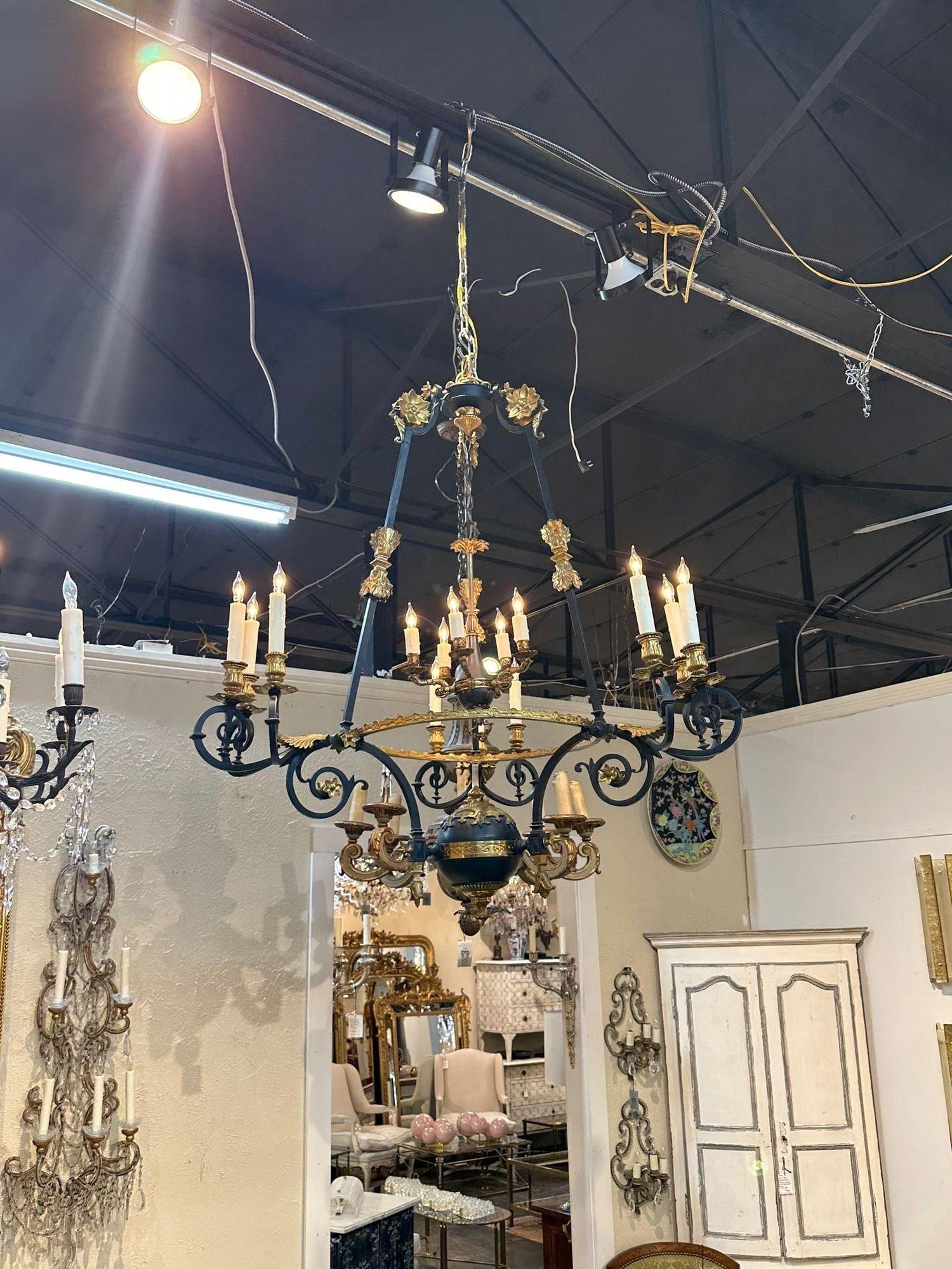 Lampadario a 14 luci in bronzo dorato e acciaio nero dell'Impero francese del XIX secolo. 1880 circa. Il lampadario è stato ricablato professionalmente, pulito e pronto per essere appeso. Include una catena e un baldacchino coordinati.