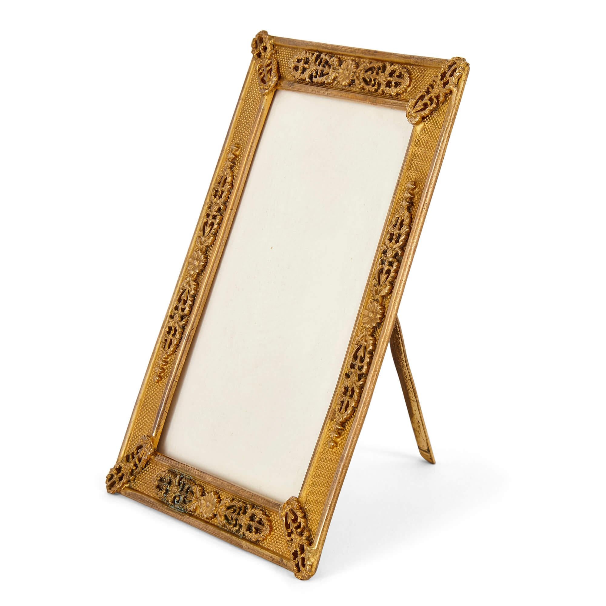 Empire gilt bronze picture frame
French, 19th Century
Measures: Height 11cm, width 8cm, depth 0.5cm

The rectangular picture frame features a stippled surface mounted with foliate and floral gilt bronze decorations in a classicising style to the