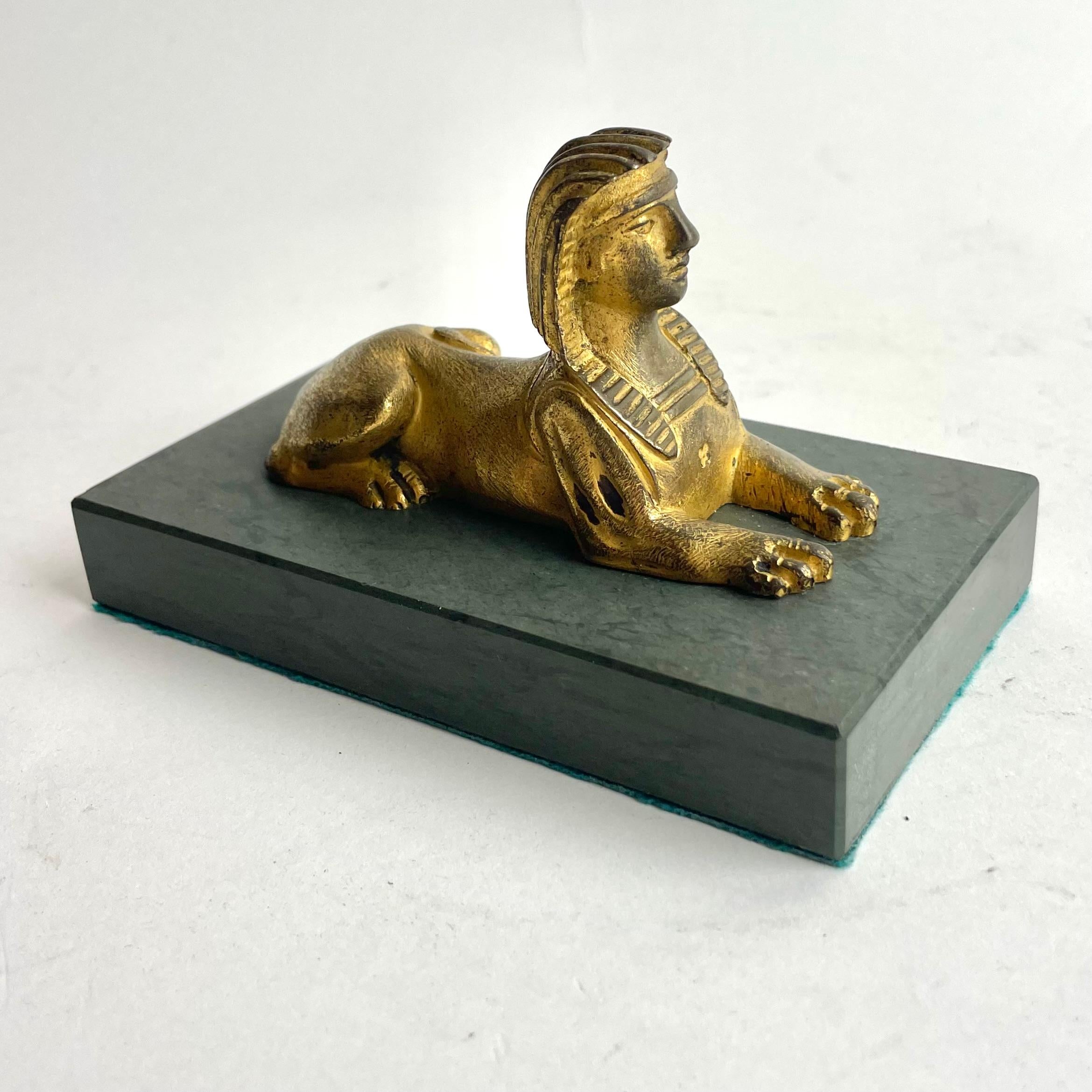 
Fermacarte sfinge in bronzo dorato impero su base di marmo, Francia, inizio XIX secolo

Un affascinante fermacarte del periodo Impero con una sfinge in bronzo dorato finemente fusa che poggia su una base rettangolare in marmo. Questo elegante pezzo