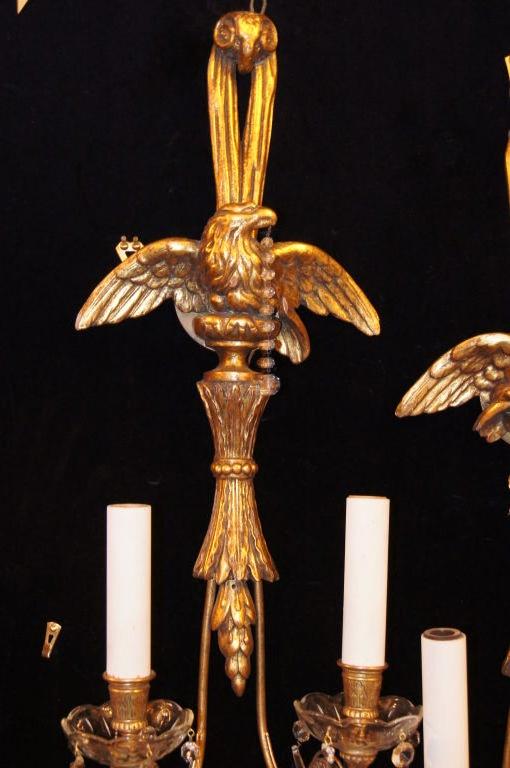 Pair of American, 1920s carved and giltwood sconces with eagle at top of body and with crystal pendants. Original gilt finish and patina. 

Measures: 28