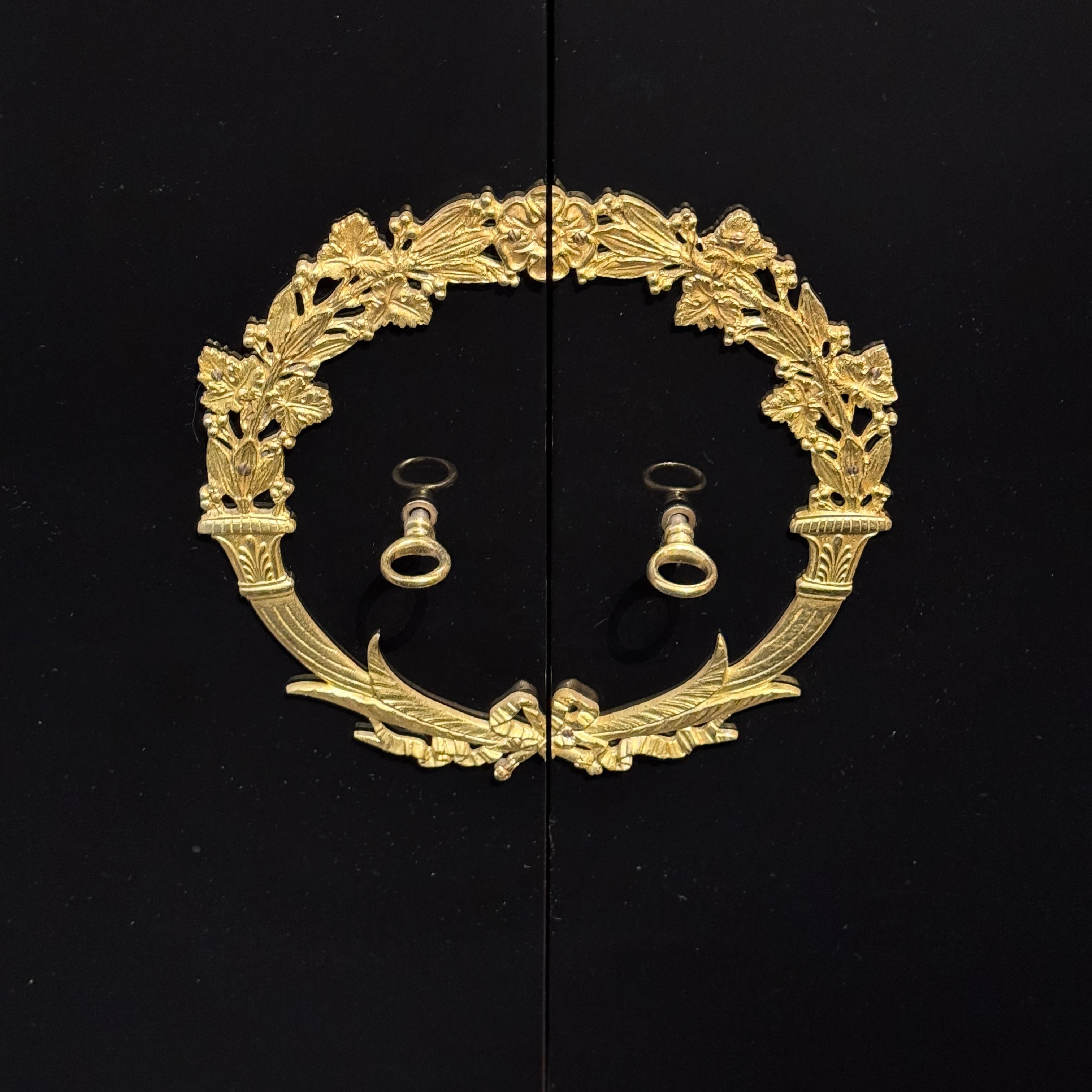 An Empire Inspired Four-Door Sideboard
Designed by De Coene Frères.
Black Lacquer with patinated Bronze details,
a Central Wreath, and Two Caryatids.
Interior lined in mahogany.
Featuring original De Coene Label.
Brussels , Belgium