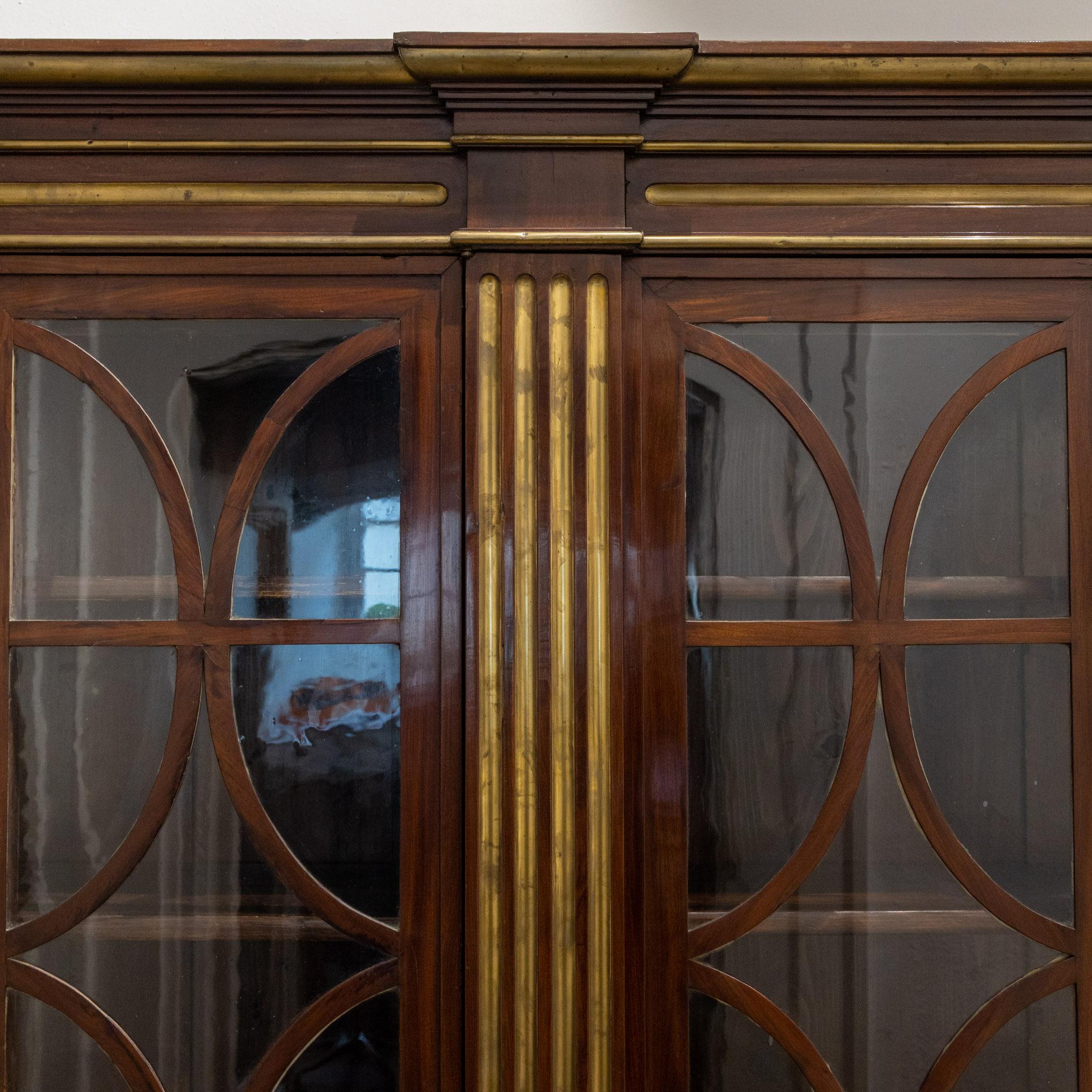 Six-door glazed bookcase with muntins and mahogany veneered body with brass fluting.