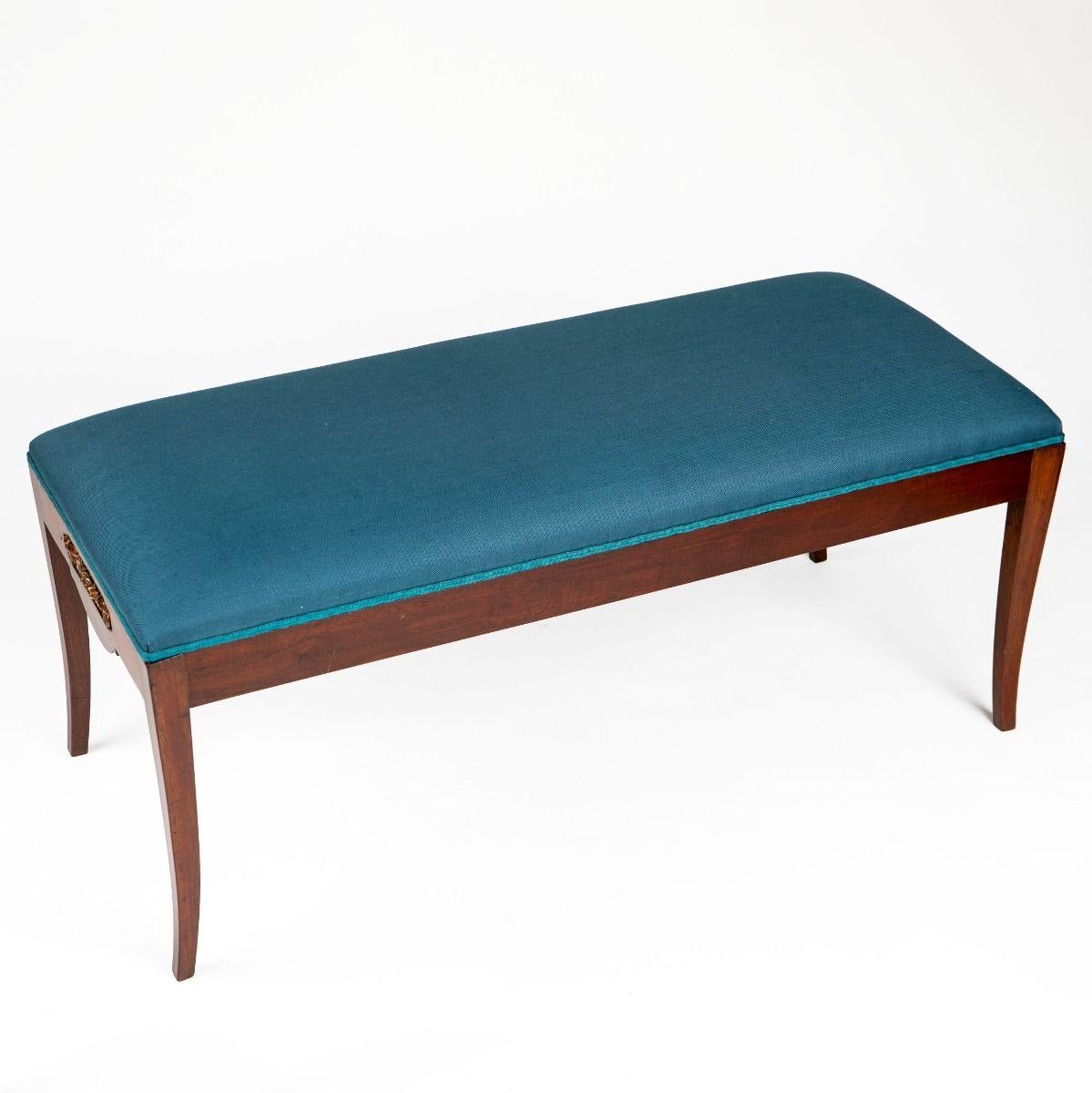 Elegant Empire bench crafted in mahogany with gently curved legs.
The end panels are adorned with satinwood line inlay and gilt bronze mounts set in ebonized fields.

The seat has been newly reupholstered in blue linen.

Denmark, c. 1810–1820