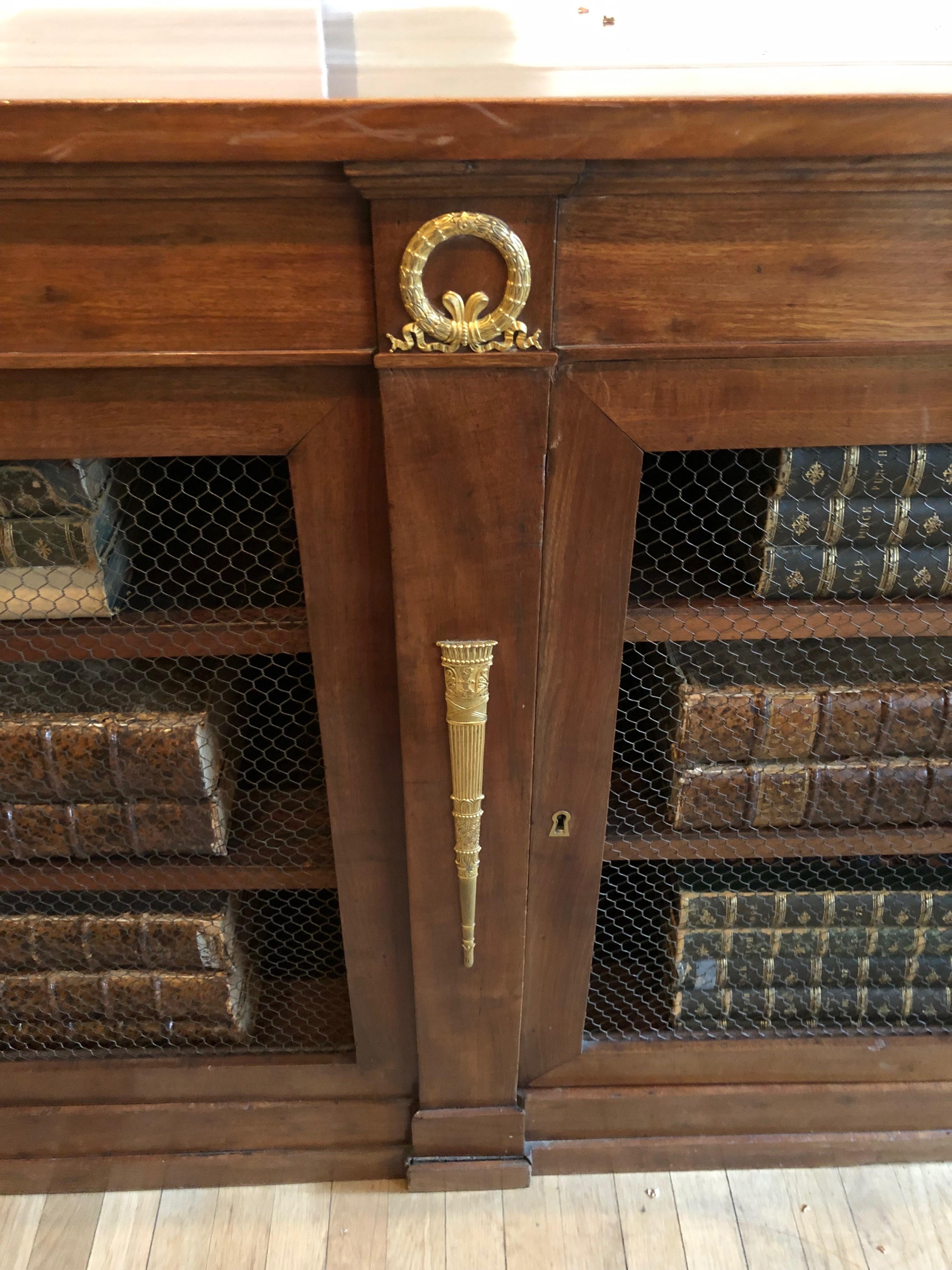 Empire mahogany bookcase,
French, circa 1815.
Measures: 39 1/4 x 63 1/2 x 19 1/8 inches.
With gilt metal mounts.