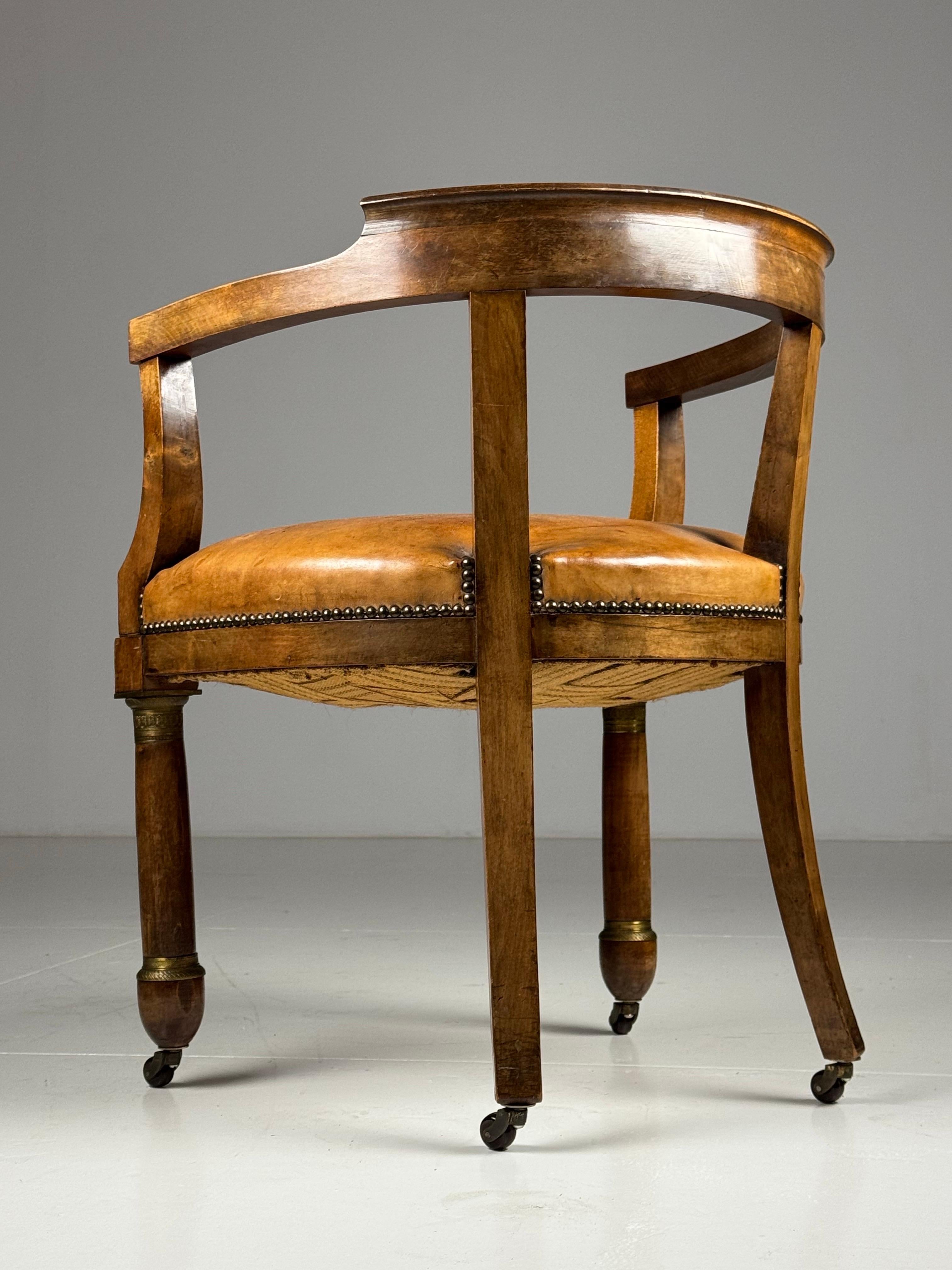 Empire Mahogany Office Chair / Armchair. Early 19th century. Seat upholstered in sheep leather. Finished all around with decorative nails. In good condition. Very light signs of use in accordance with age.

Dimensions: W60.5 x D52 x H74