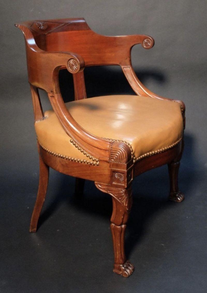 The desk chair with carved diamond motif on crest and richly carved griffin wings above articulated paw feet with tan colored leather upholstery. Height: 30