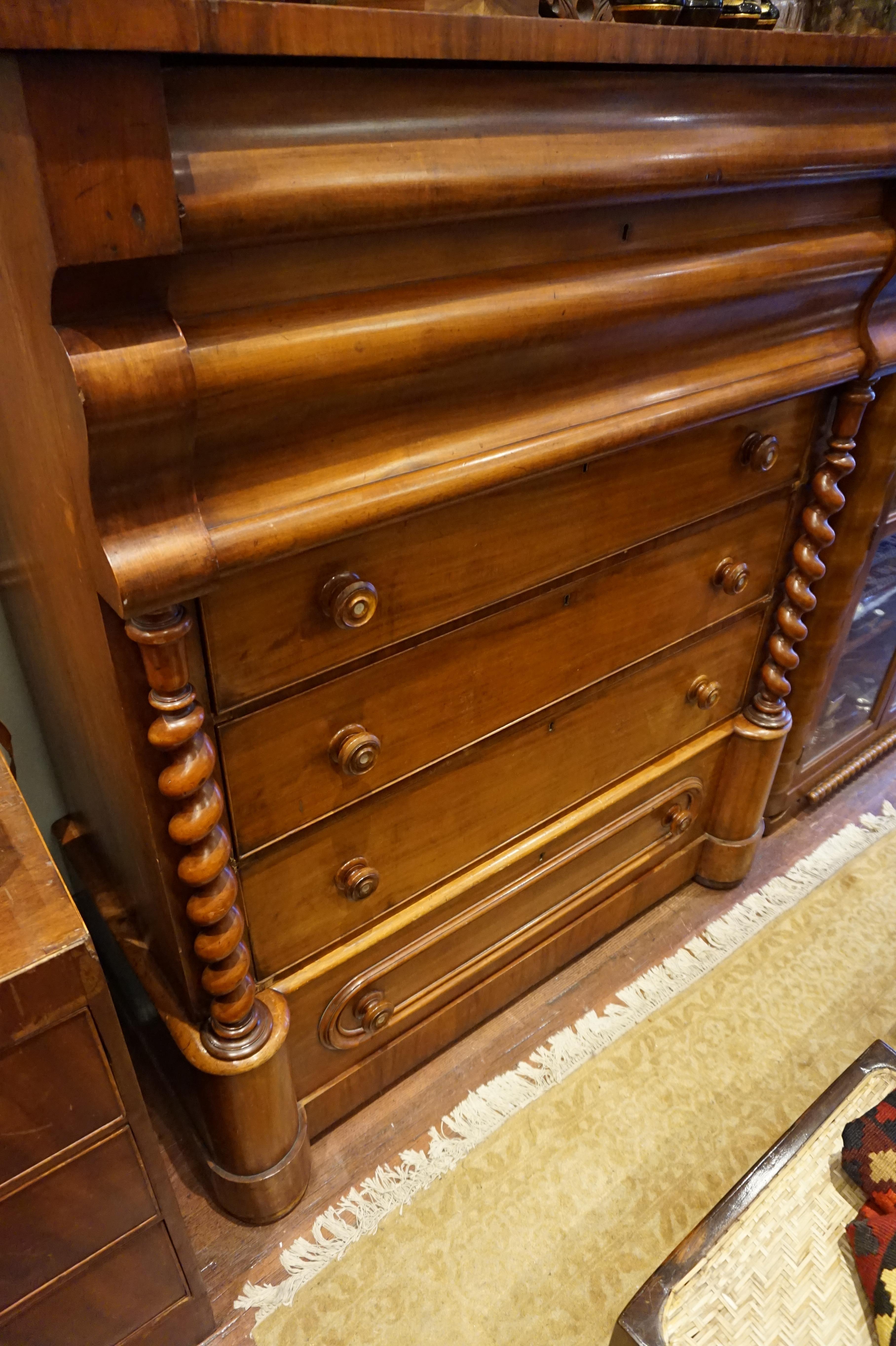 Empire mahogany highboy dresser circa 1830-1840 with sectionals and graduated drawers. Barley twist columns flank the sides of this stately piece. Fine dovetailing and mother of pearl inlay on handles subtly distinguish this piece. Some nicks and