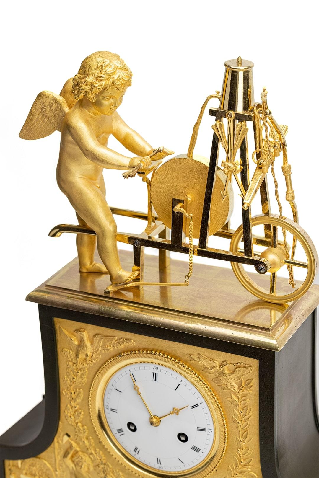 Pendule de cheminée Empire romantique en bronze au feu de mercure doré. Attribué au célèbre atelier de Thomire à Paris. Vous voyez un ange qui travaille comme un forgeron en aiguisant ses flèches d'amour. La combinaison des bronzes au mercure de
