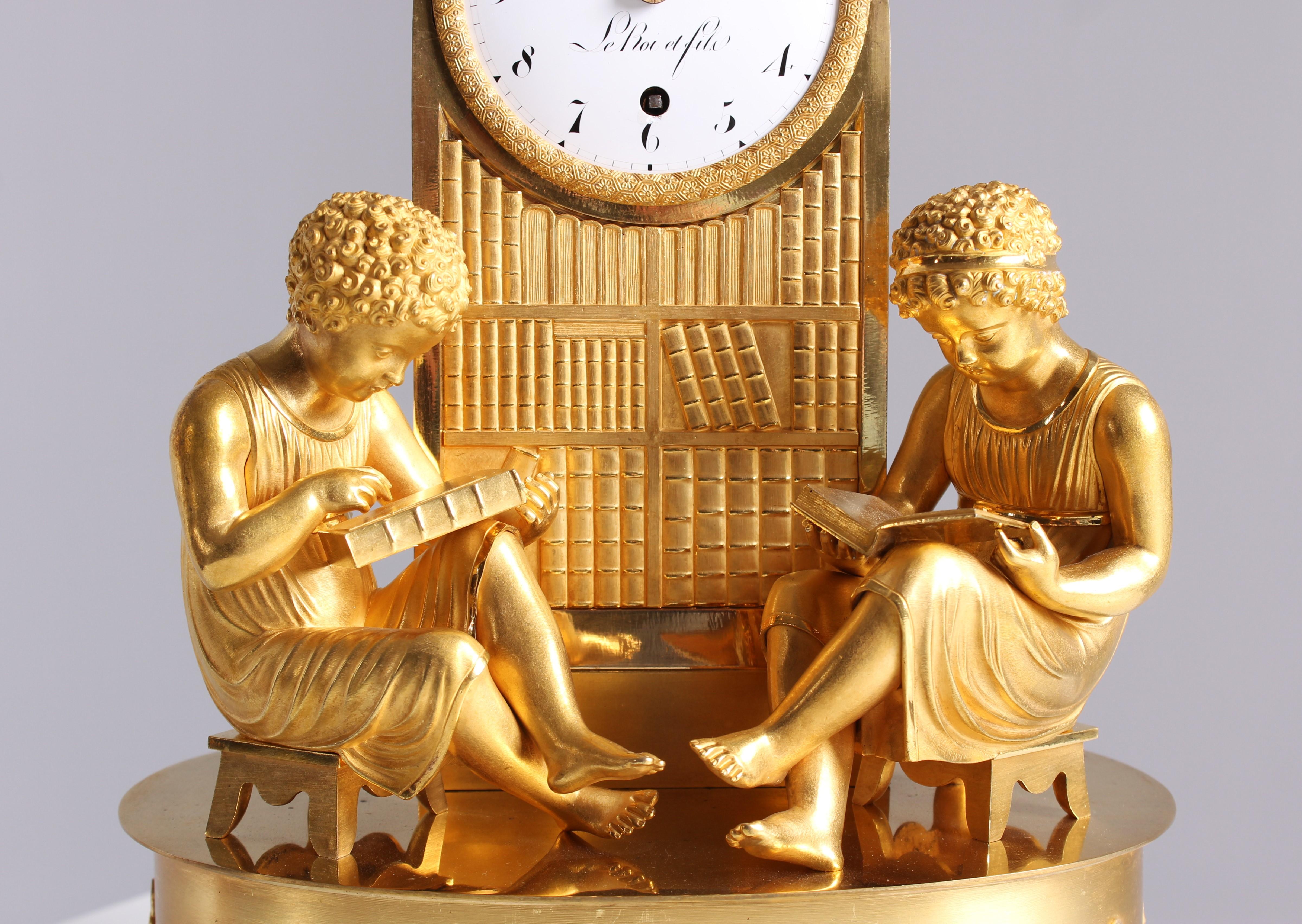 Mantel Clock - La Bibliotheque - In the study room

Paris
fire-gilt bronze, enamel
Empire around 1820

Dimensions: H x W x D: 38 x 28 x 19 cm

Description:
Scenery mounted on an oval base decorated with applied flower garlands. Two children, seated