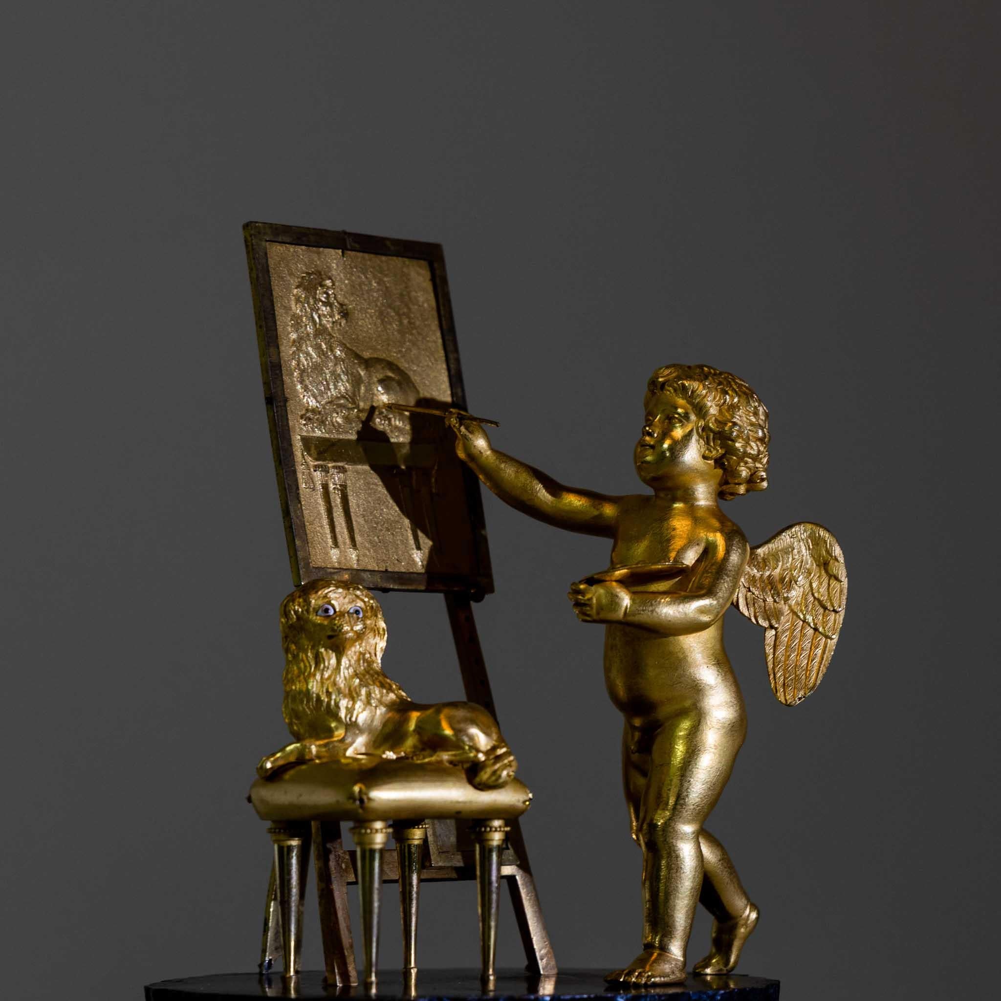 Fire-gilt and burnished bronze pendulum clock with Amor as painter. The case is made in the shape of a tree stump and stands on a smooth plinth with lion paws. The enamel dial with Roman hours is signed: Dubuc H.ger (Horloger) à Paris. The fire-gilt