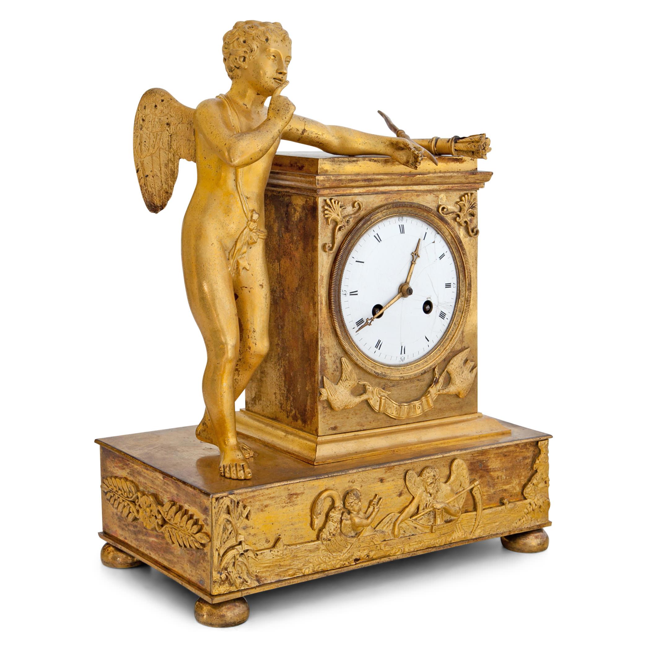 French Empire mantel clock with cupid, holding a ring between is index finger and thumb. He placed his bow and arrows casually on the clock case, that identifies him as “Amor” towards the base. In the spirit of “Love outlasts the test of Time”: The
