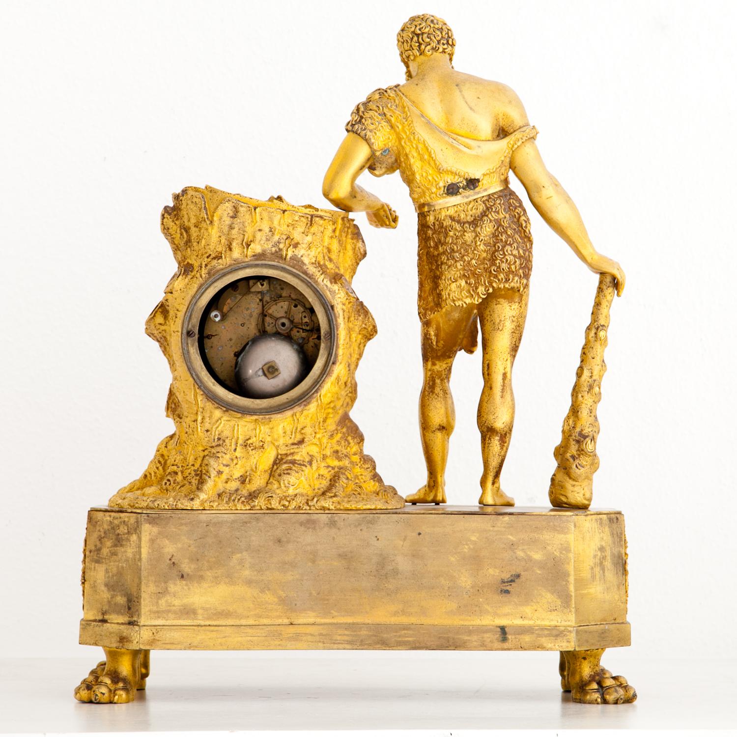 Large Empire pendula clock with depiction of Hercules, leaning on a tree trunk, housing the clockwork. The enamel clock face is signed “Rodin à Paris”. The octagonal base with lion’s paw feet shows Hercules’ attributes as well as caduceus-ornaments