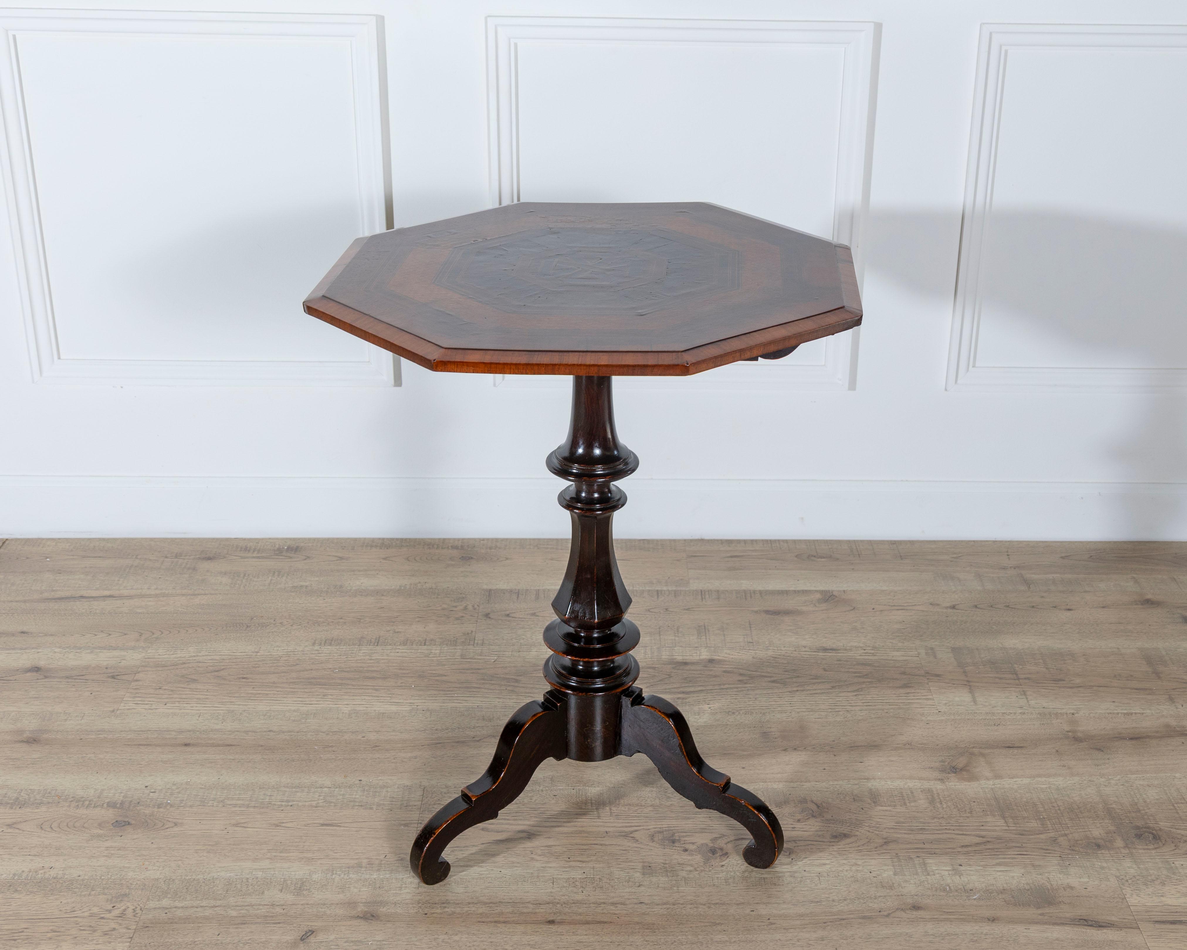 An exquisite Empire octagonal sail table, crafted in Milan during the first half of the 19th century, showcasing the elegance and refinement of Italian design. The octagonal top is richly veneered in a striking composition of mixed precious woods,