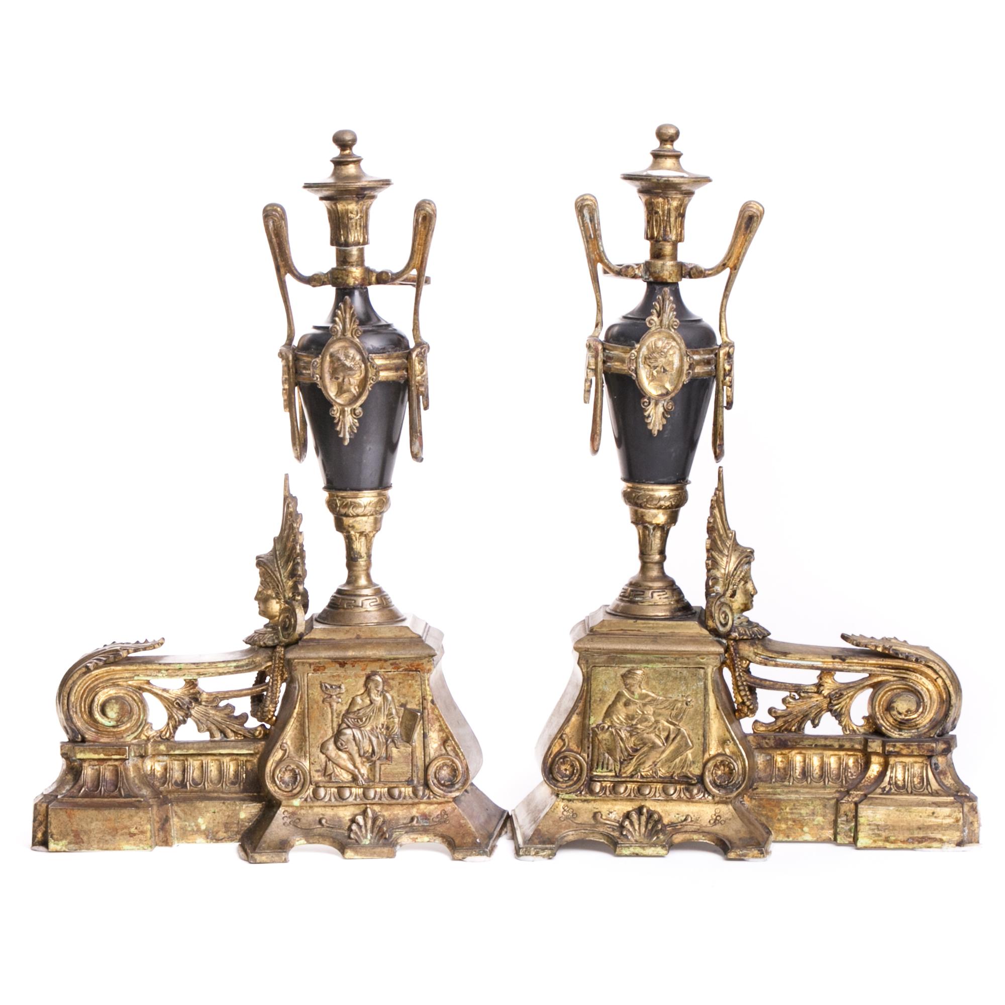 Fine example of Empire ormolu firedogs or andirons made of gilt bronze, in the so-called ormolu technique, from the 19th century. 

The bases are richly decorated with volute drifts, acanthus leaves motifs and palmetto shells, as well as relief