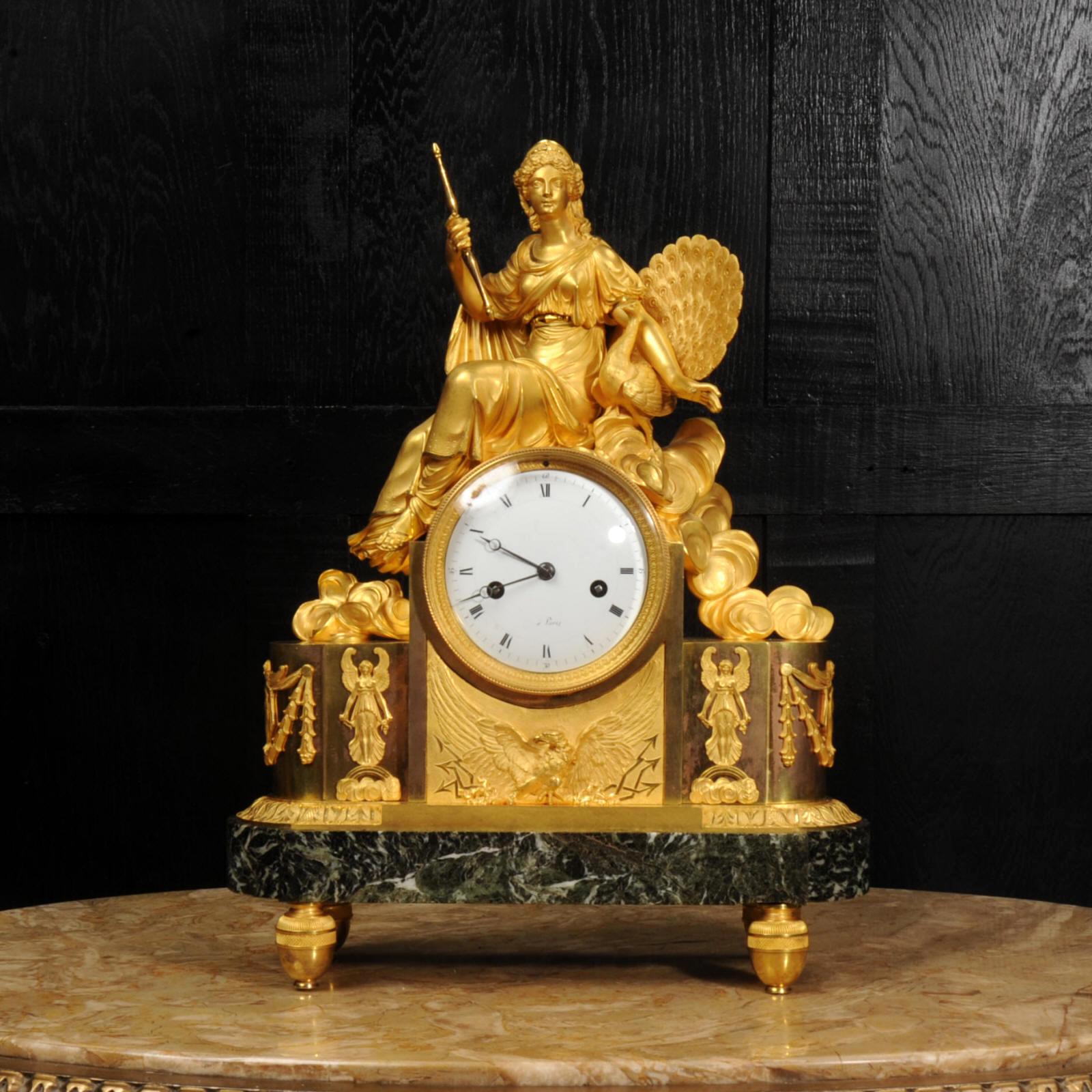 A rare and fine original antique French Empire clock featuring the goddess Juno. Beautifully made in sumptuous mercury fire gilded bronze, Juno is seated with a peacock amongst the clouds. The fine chasing and finishing of the bronze gives a
