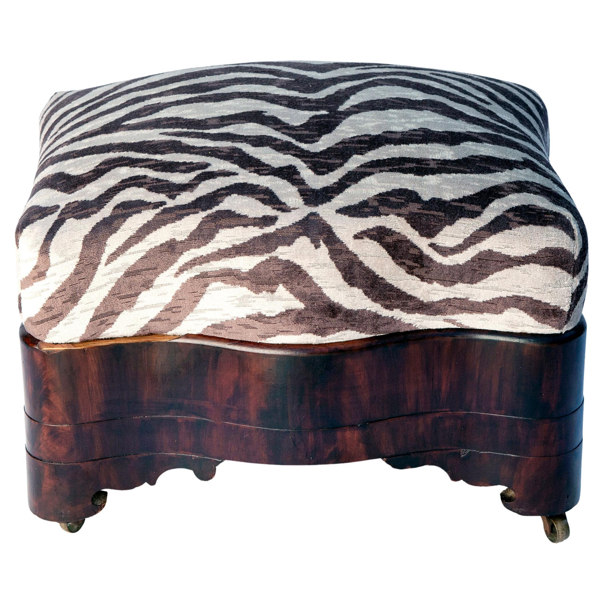 Flame mahogany curvy 19thC English Empire period ottoman in Italian Zebra Upholstery on the original casters.