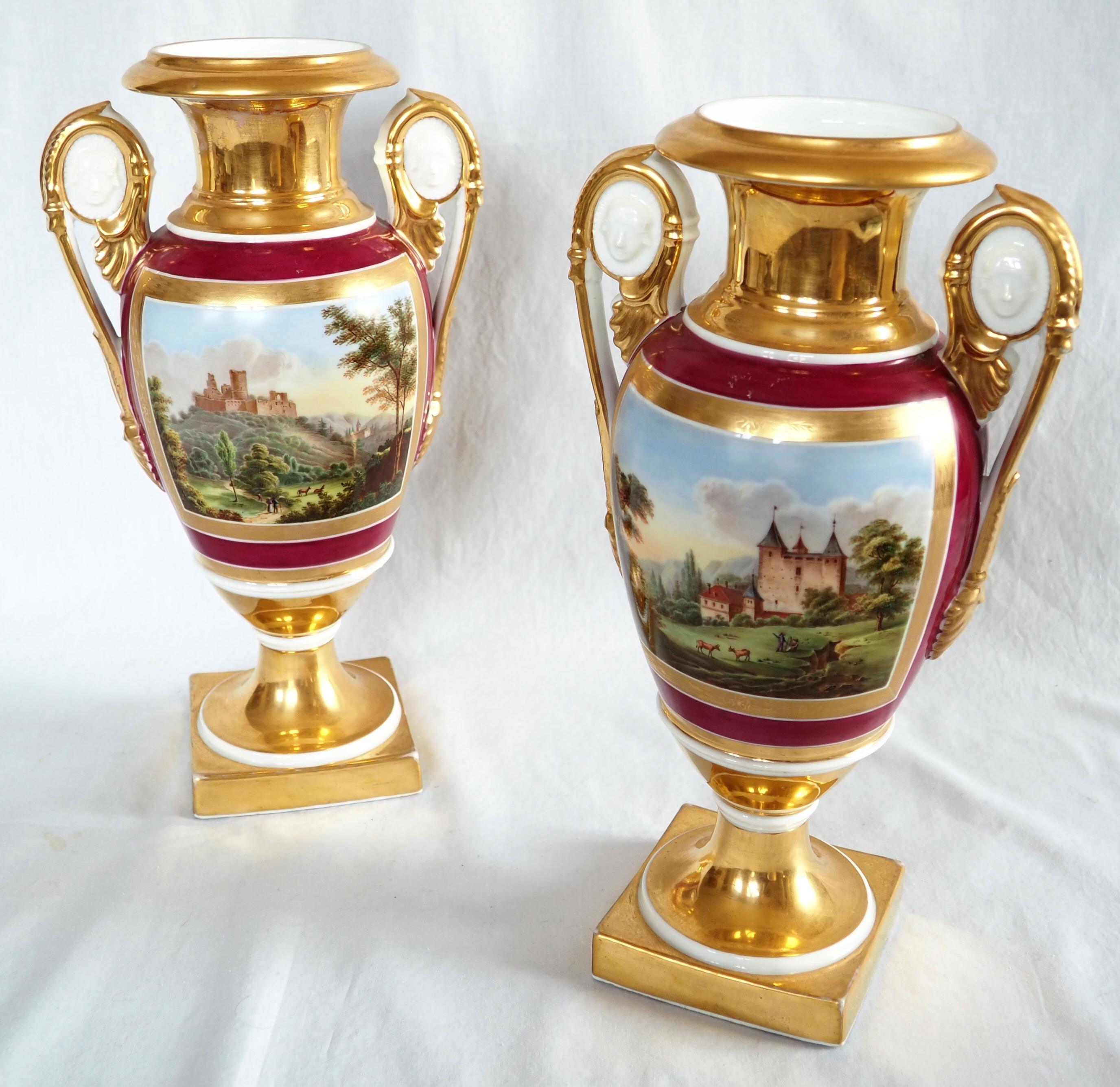 A fine antique pair of Paris porcelain vases, early 19th century high-end French production circa 1830 (Empire style, Restauration period).
Fully decorated model : polychromatic hand-painted romantic landscapes framed with a matte gilt pattern on a
