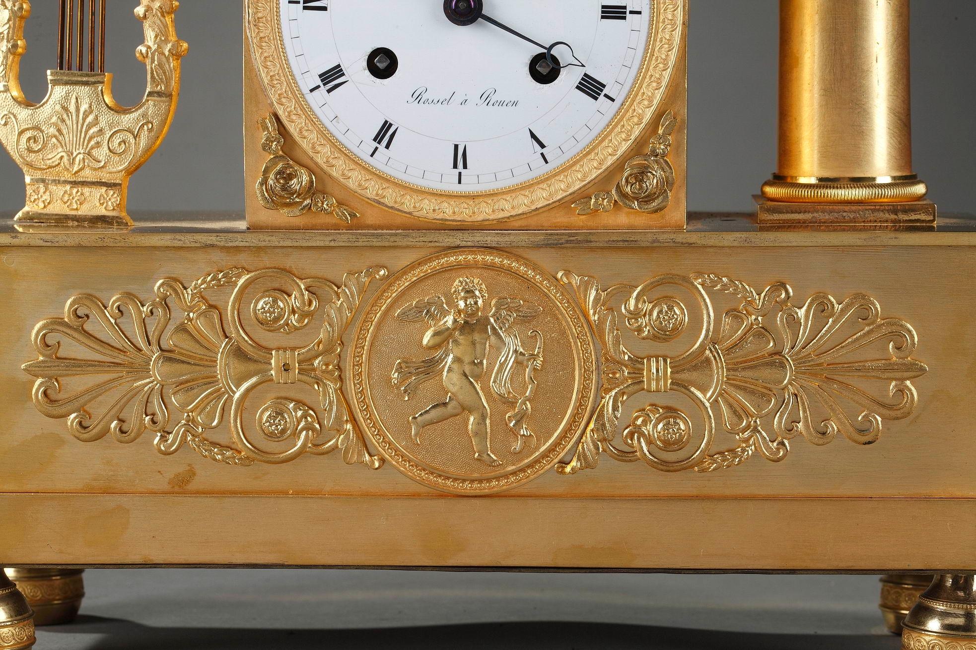 French Empire pendulum clock finely crafted of gilt bronze, featuring a young spinner wearing a classical dress, seating on the dial near a lyre and an ewer. The base is accented by generous scrolls, palmette and a central medallion with Cupid. The