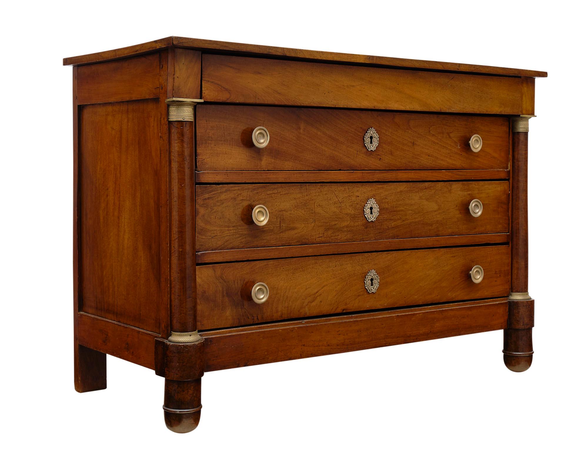 Empire Period antique chest of drawers made of solid walnut and finished with a lustrous French polish. The half detached columns give it a striking appearance and we love the functional four dovetailed drawers. The hardware is all finely cast