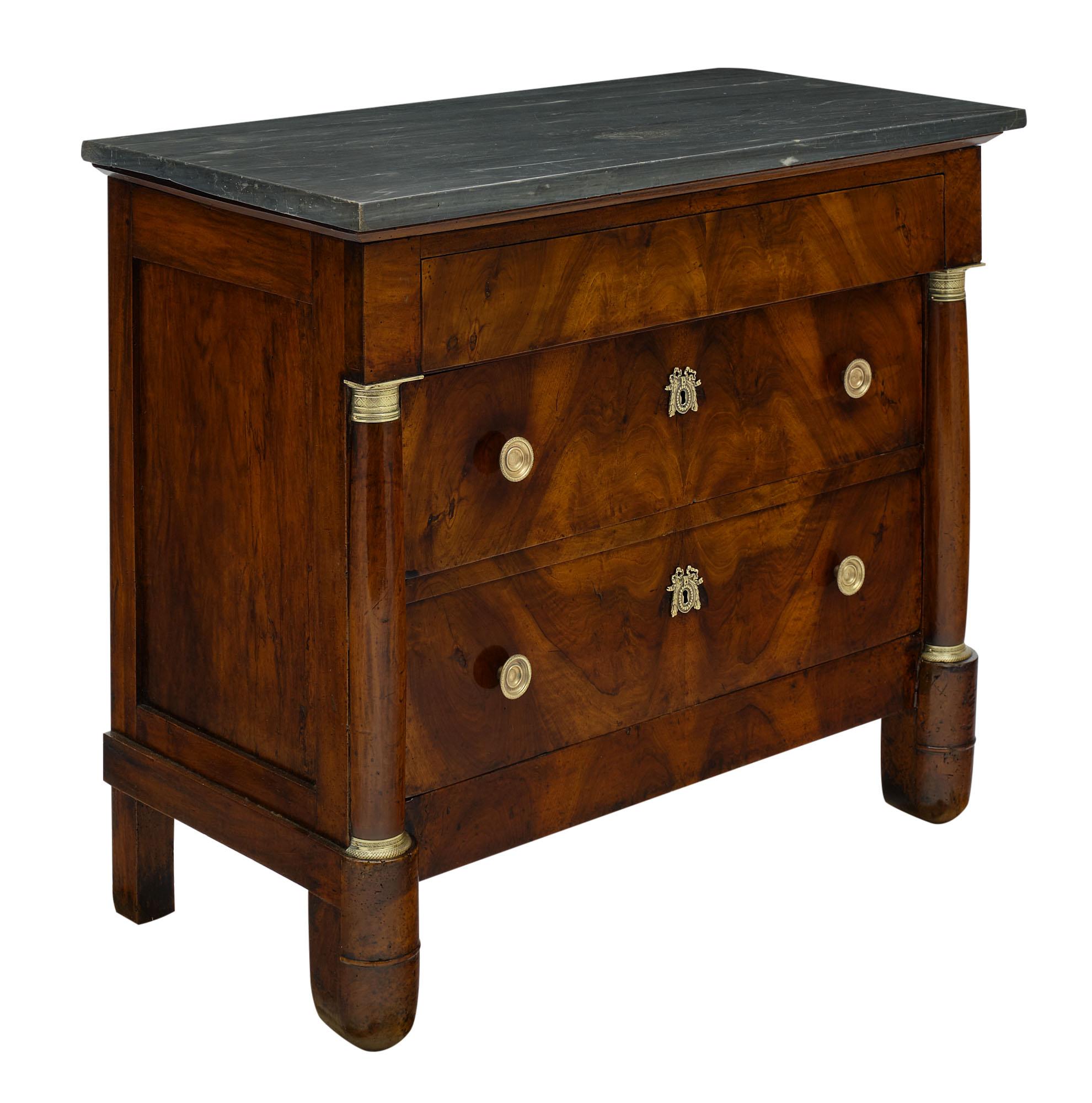 Chest of drawers from the French Empire Period made of solid walnut and burled; figured walnut. There are three dovetailed drawers with finely cast hardware and an intact gray Turkin marble slab on top.