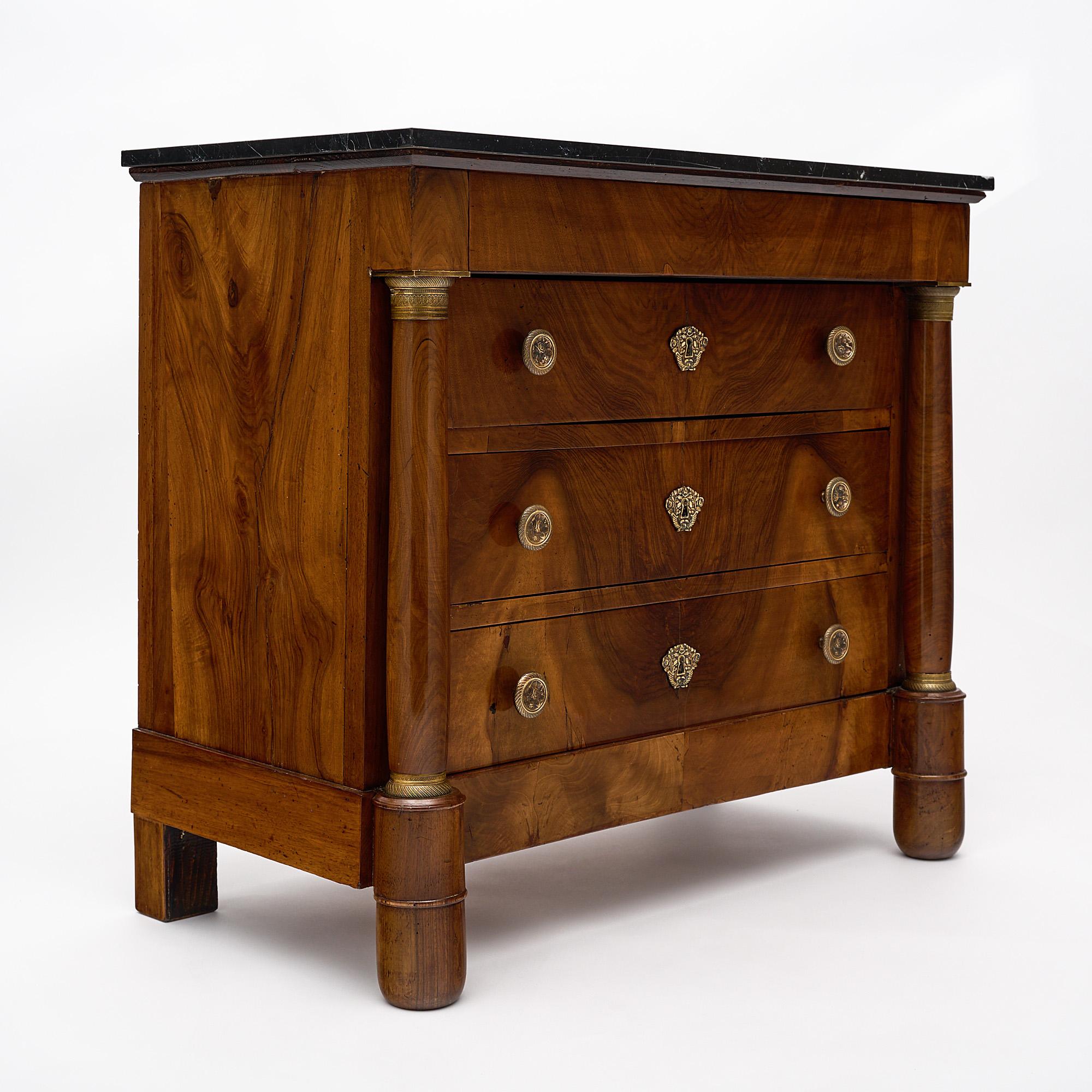 Chest of drawers, French, from the Rhone Valley. This Empire period piece is made of solid figured walnut. The solidly crafted cabinet features four dovetailed drawers with original finely cast bronze hardware. The detached columns are typical of