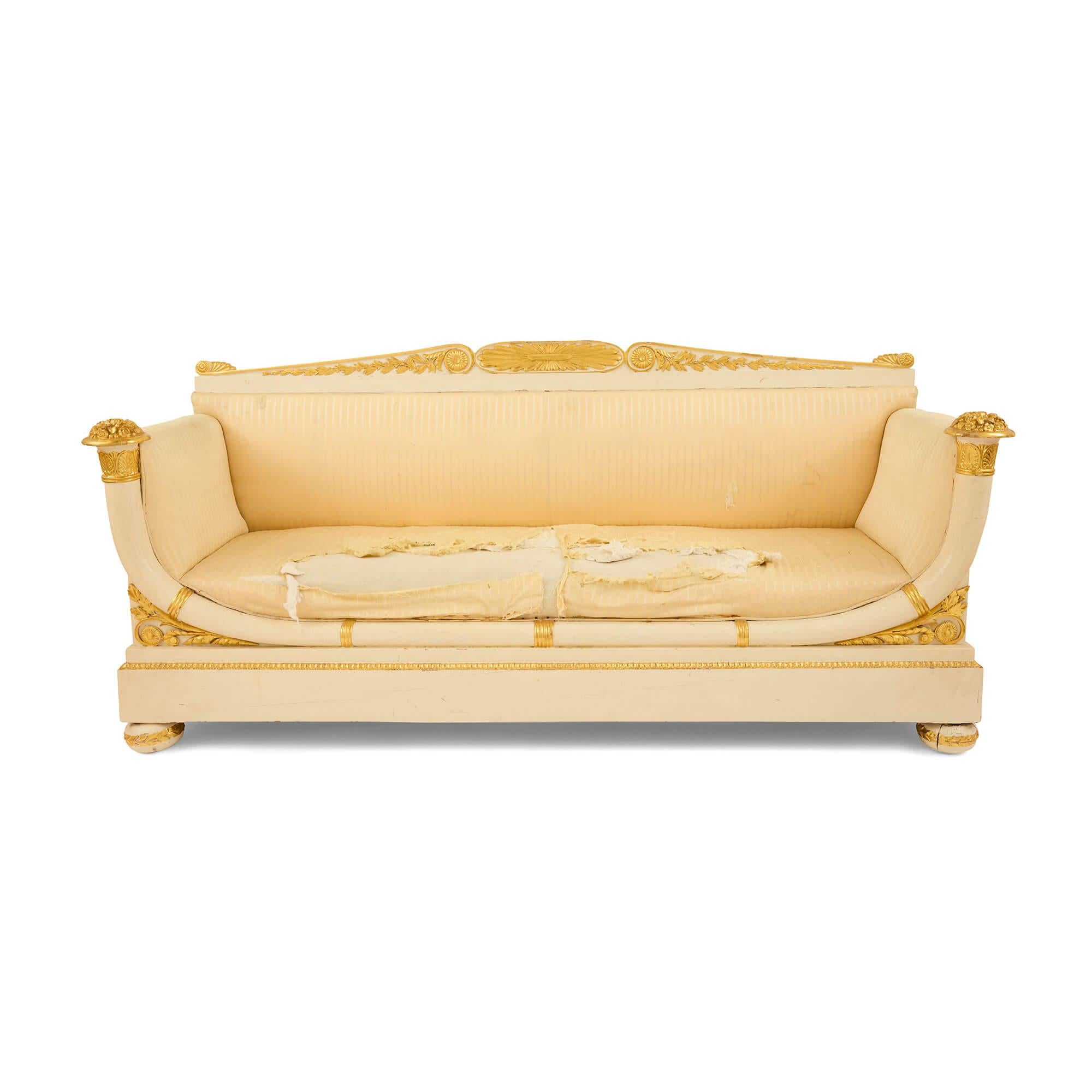 Empire period gilt and painted wood three-piece salon suite
French, c. 1820
Sofa: Height 101cm, width 213cm, depth 72cm
Chairs: Height 101cm, width 61cm, depth 56cm

This exquisite three-piece salon suite, crafted during the Empire period, embodies