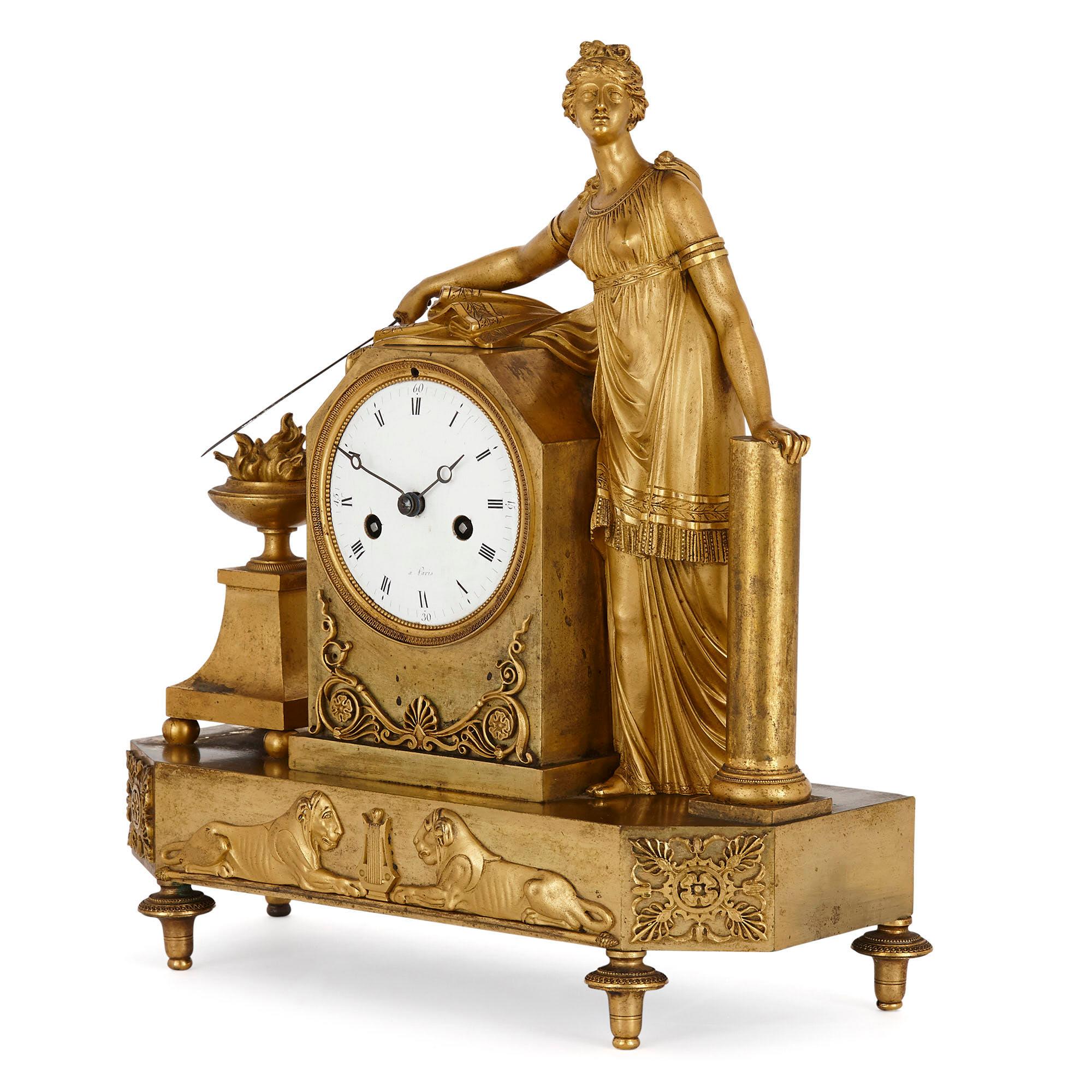 Pendule de cheminée figurative en bronze doré d'époque Empire
Français, début du 19e siècle
Mesures : Hauteur 33cm, largeur 31cm, profondeur 12cm

Cette superbe horloge de cheminée est un merveilleux exemple du type d'horloge qui prévalait à