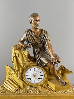 Reloj de chimenea de época imperio en bronce dorado y patinado