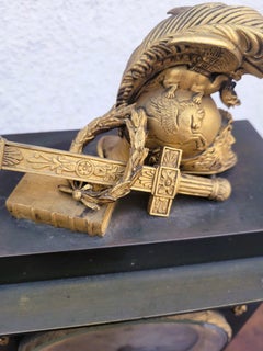 Kaminuhr aus patinierter und vergoldeter Bronze mit Kriegstrophäen aus der Empire-Zeit, 19. Jahrhundert
