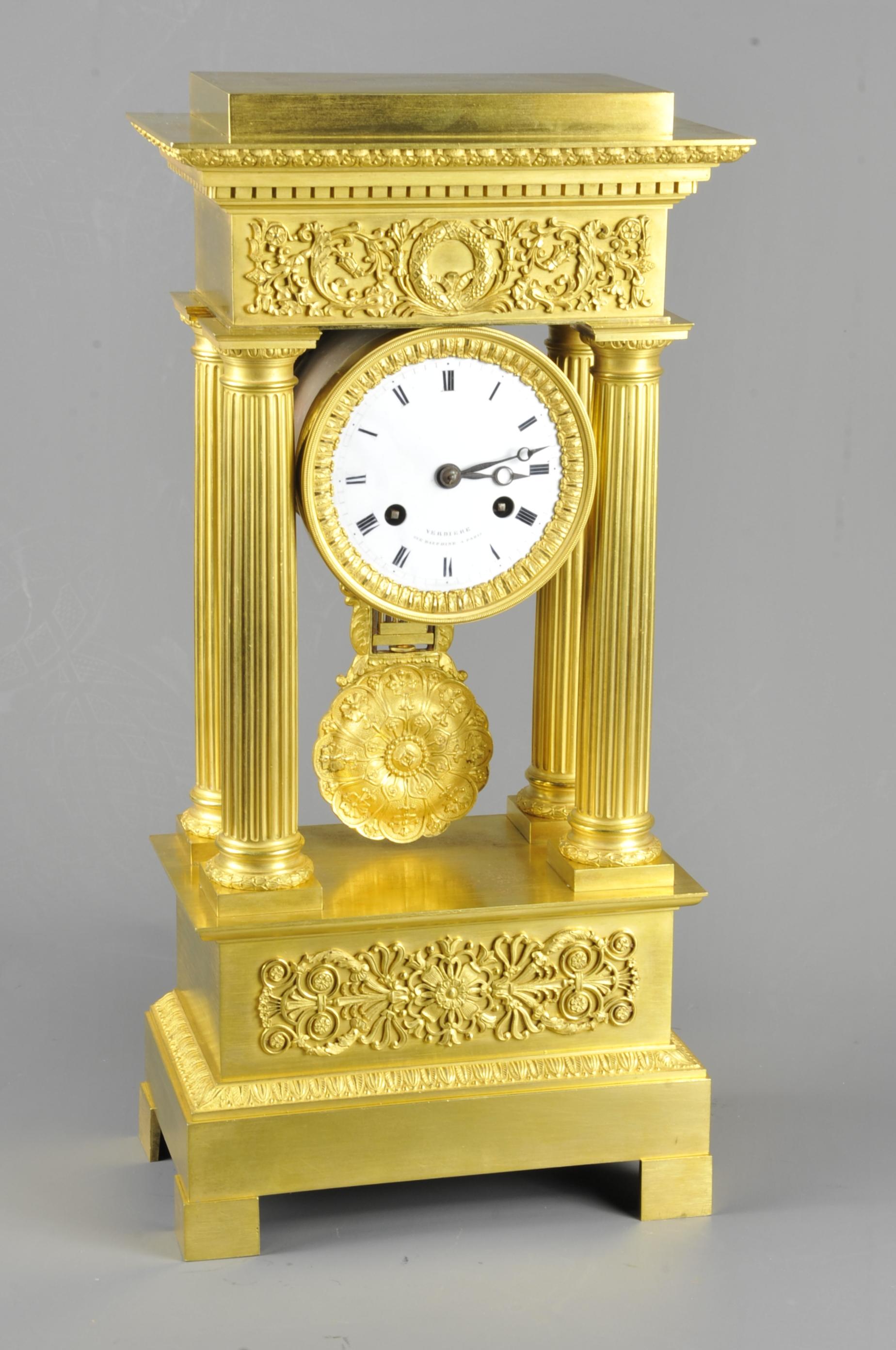 Beautiful portico clock with four Doric columns and applied ornamentation decorated with foliage, crown and masks in the style of the Empire.

In the upper part a beautiful pediment with friezes of gadroons and dentils.

CIRCA